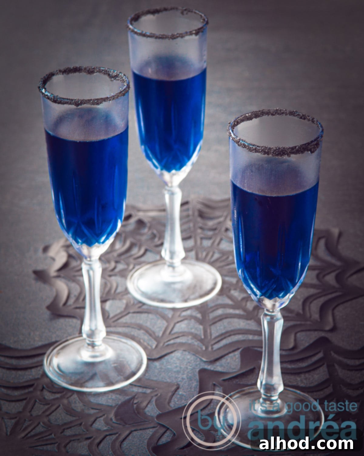 A collection of vibrant Halloween Blues Cocktails with black sugar rims, garnished for a festive party setting.
