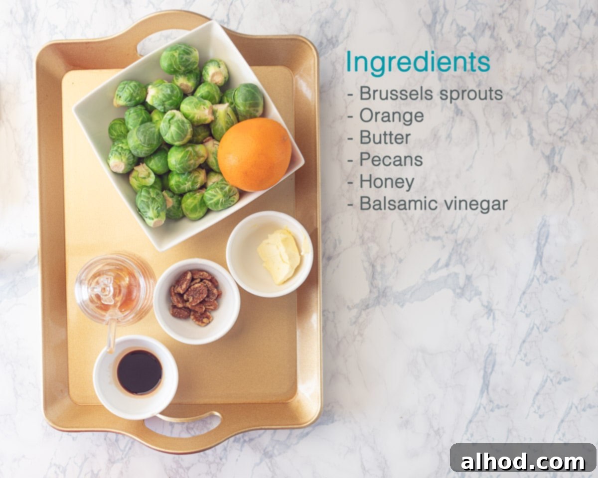 Zesty Orange Glazed Brussels Sprouts 3 A golden serving tray displaying all the fresh ingredients needed for Orange Glazed Brussels Sprouts, including fresh Brussels sprouts, an orange, butter, honey, balsamic glaze, and pecans, set against a pristine white marble background with an ingredient list to the side.