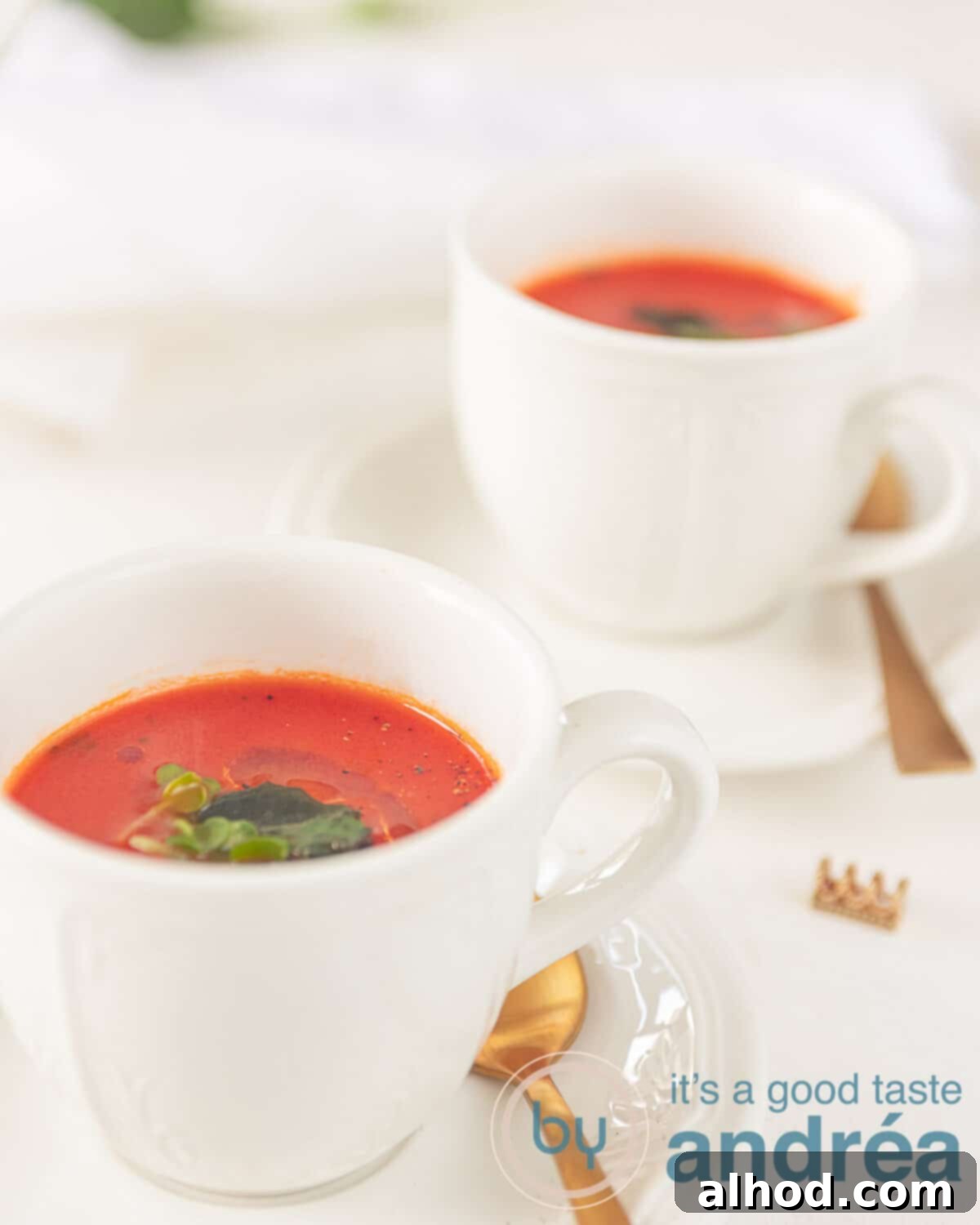 Garden Fresh Tomato Soup 8 Two inviting bowls of rich homemade tomato soup, beautifully garnished with fresh basil leaves and a delicate swirl of olive oil, ready for serving.