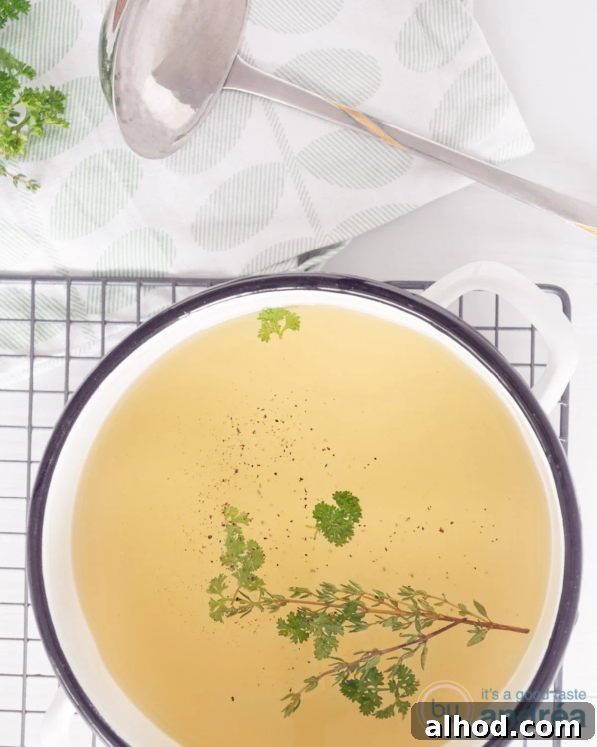 Homemade vegetable stock in a bowl with some herbs