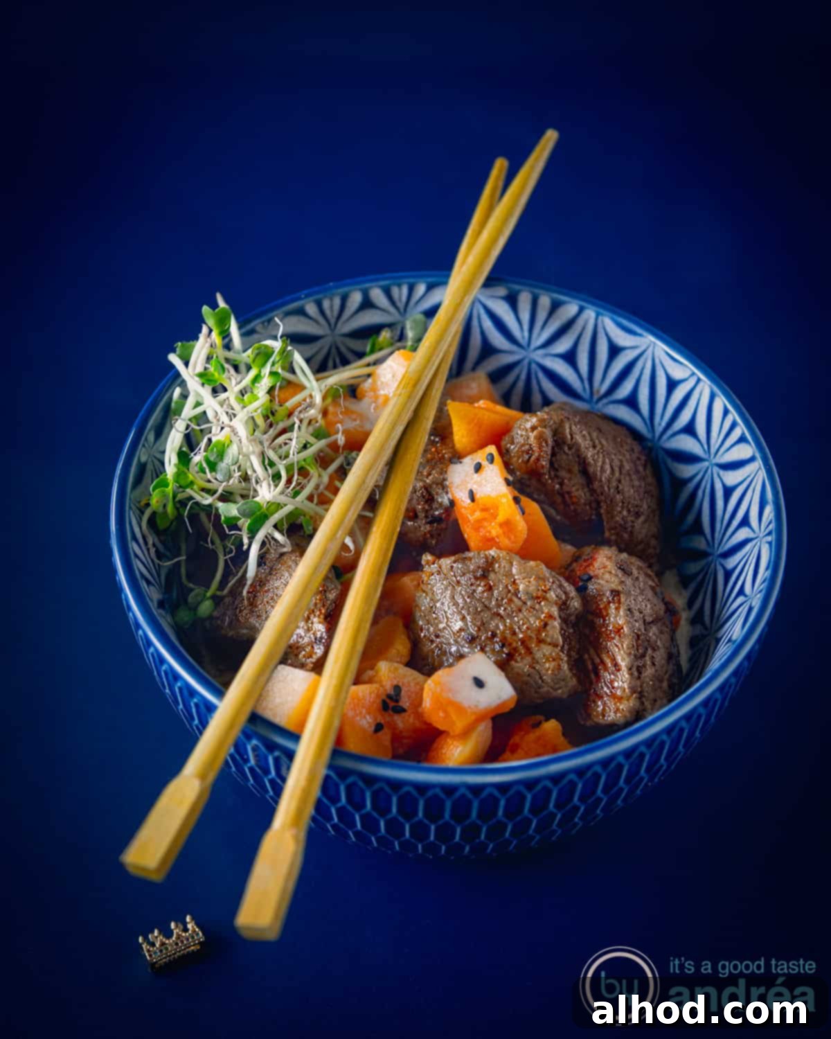 Speedy Rich Beef and Pumpkin Curry 3 Pompoen curry, a vibrant blue bowl filled with creamy beef and pumpkin curry, artfully arranged on a pristine white background. The rich colors of the curry contrast beautifully with the bright white, creating an inviting visual. Golden chopsticks rest delicately beside the bowl, hinting at the delicious meal within.