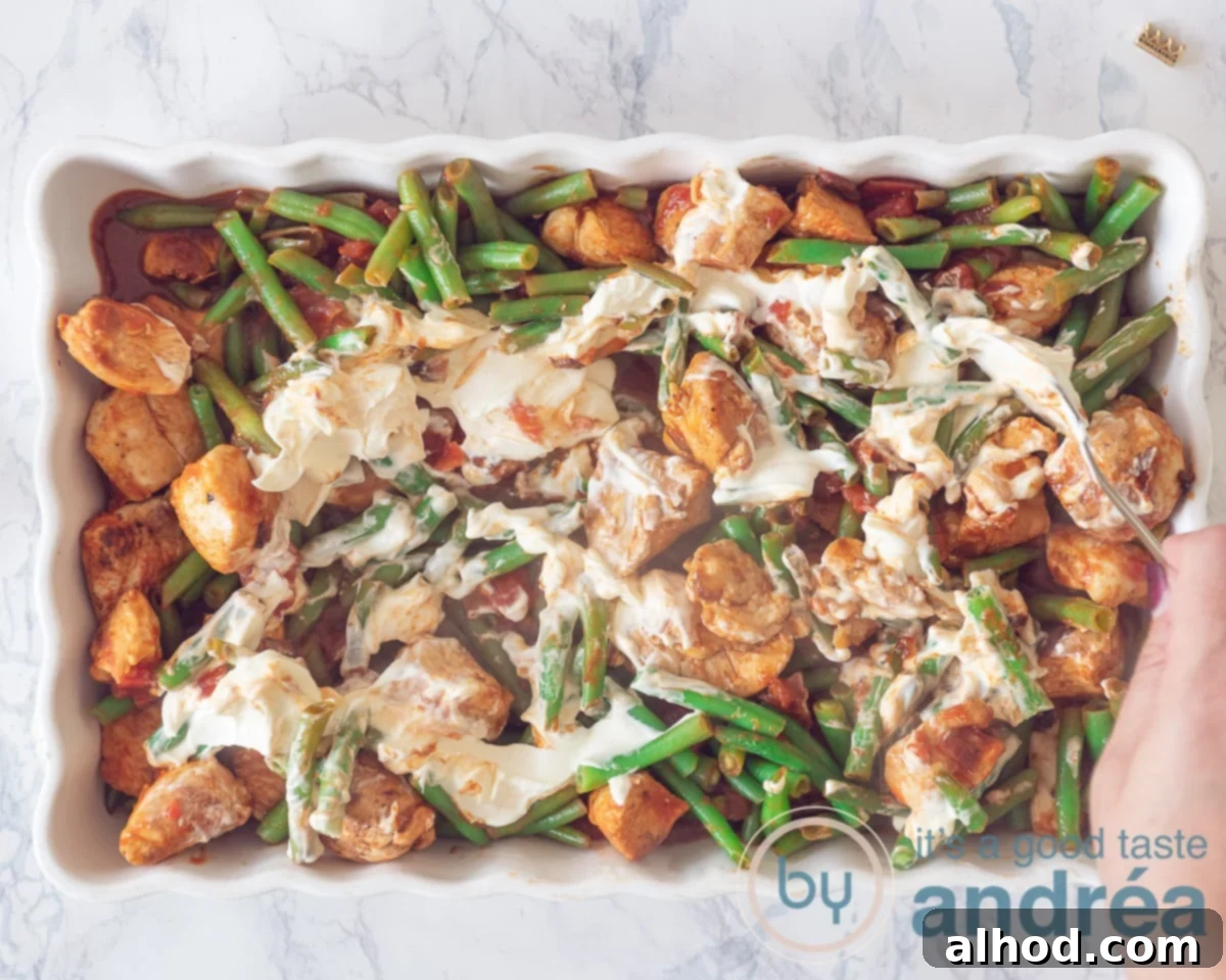 Loaded Chicken Nacho Bake 7 Over de kip, boontjes en tomatensaus is een crème fraîche topping verdeeld.