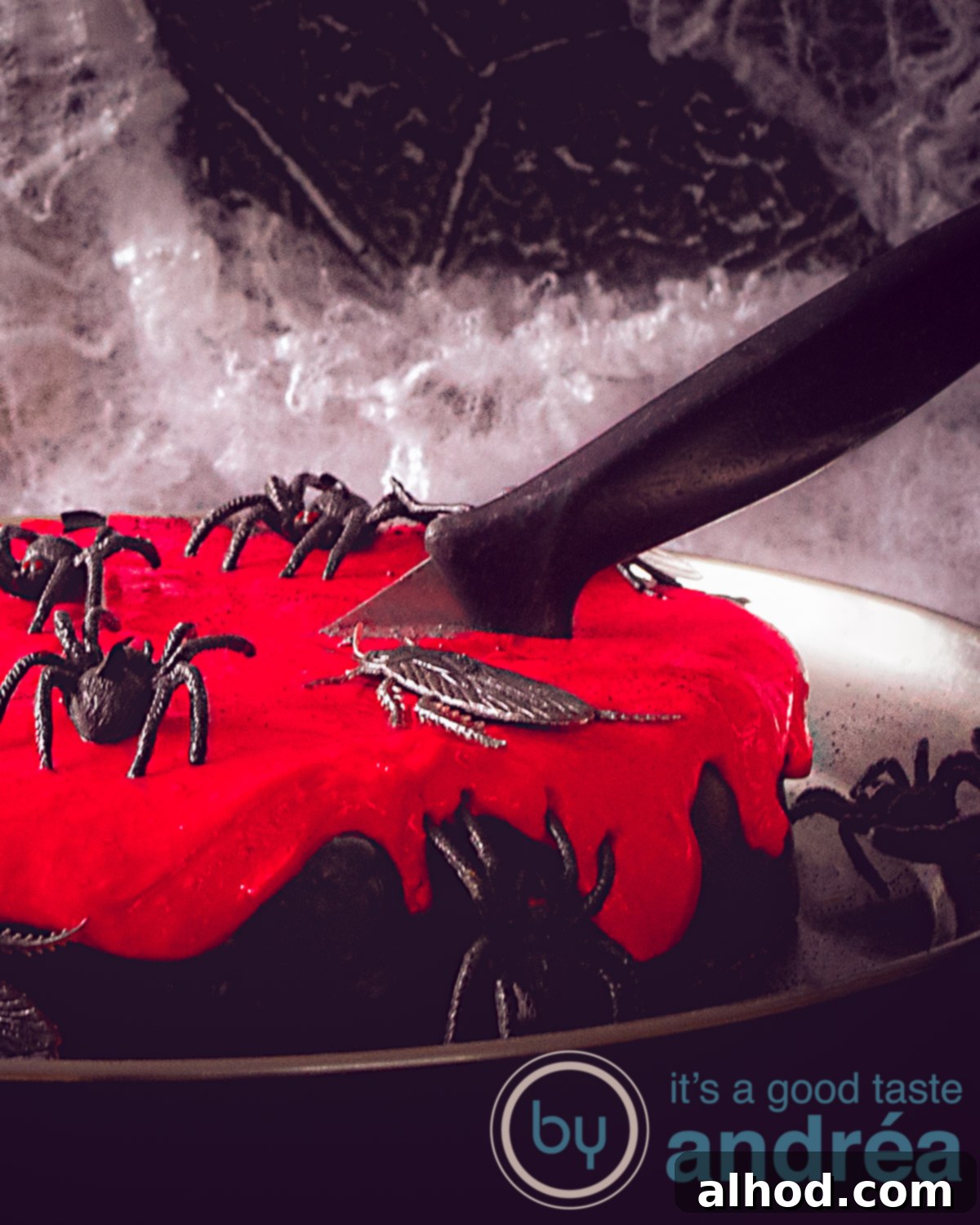Ghoulishly Good Chocolate Cake 2 Halloween chocolate cake with cream cheese topping on a black background. A knife inserted in the cake