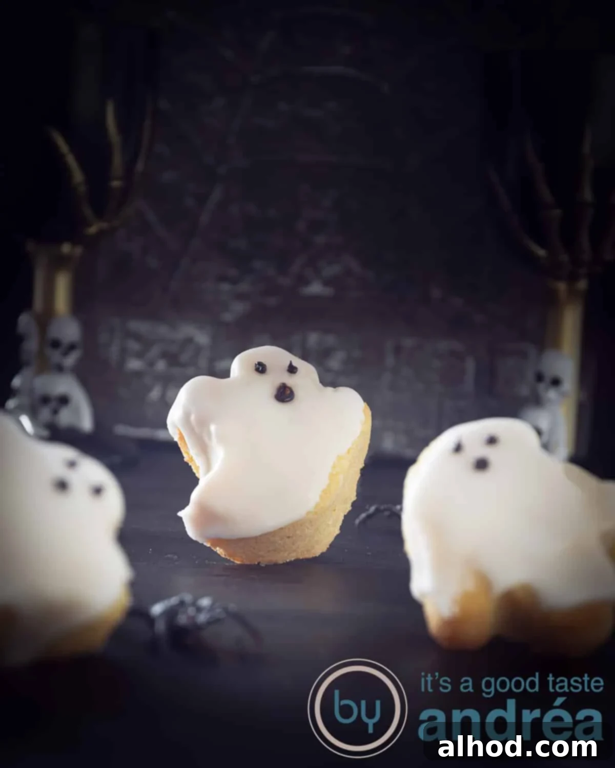 Haunted Cupcakes with Chocolate Ghost Faces 2 Three cute cake ghosts with chocolate faces on a dark surface, decorated in a Halloween style