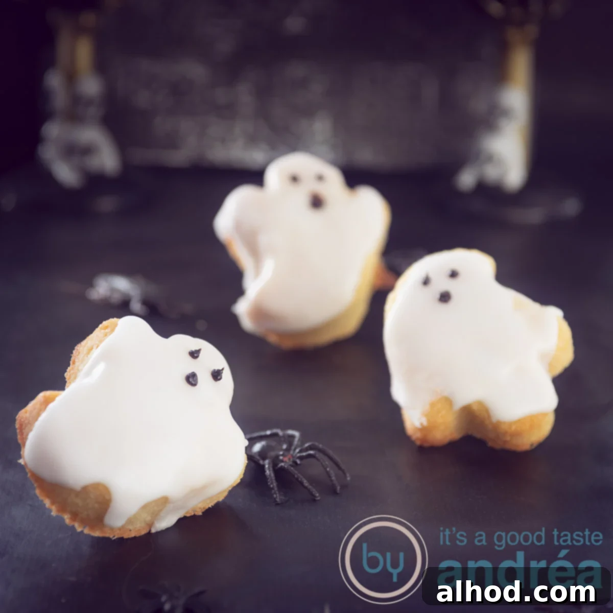 Grinning Ghost Halloween Cupcakes 4 A square photo with three ghost cupcakes on a dark background, showcasing their spooky chocolate faces