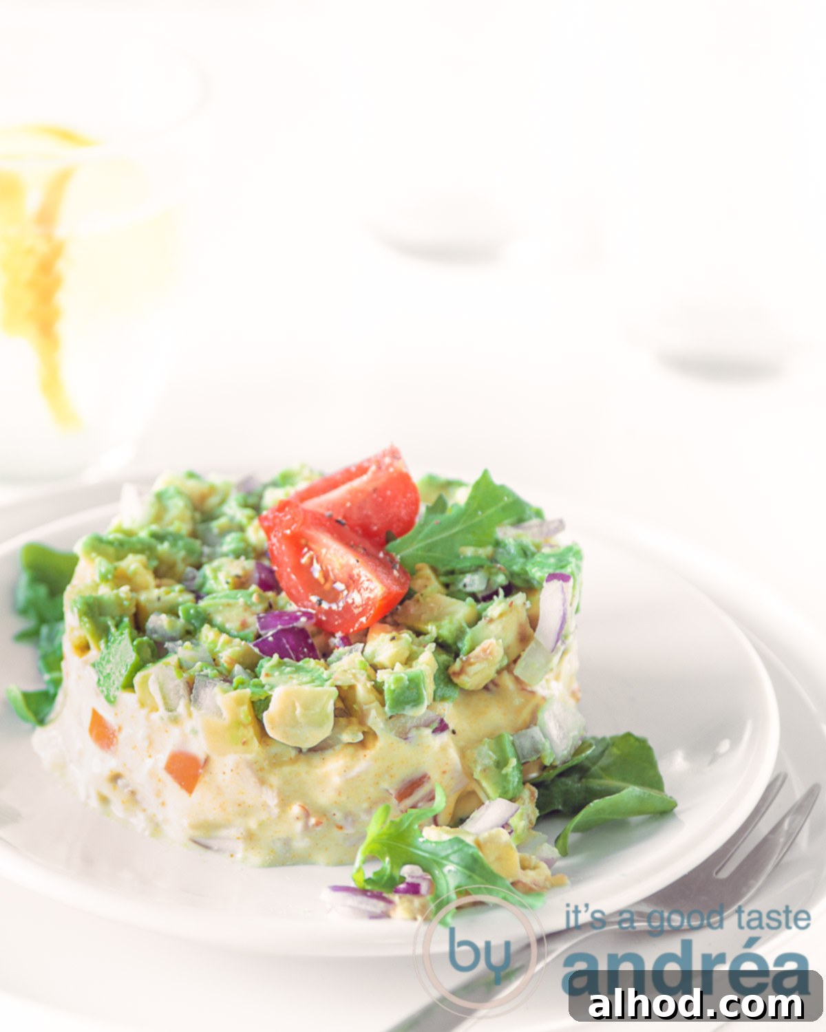 Smoky Chicken Avocado Bites 5 Smoked chicken and avocado salad tower, elegantly plated and ready to serve, adorned with cherry tomatoes.