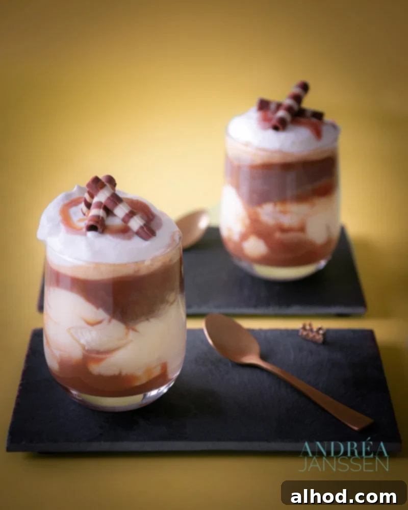 Velvet Chocolate Vanilla Banoffee Cappuccino 2 Two beautiful glasses of Chocolate Vanilla Cappuccino Banoffee, layered with ladyfingers, banana, caramel, vanilla custard, chocolate custard, and whipped cream, drizzled with caramel and chocolate flakes.