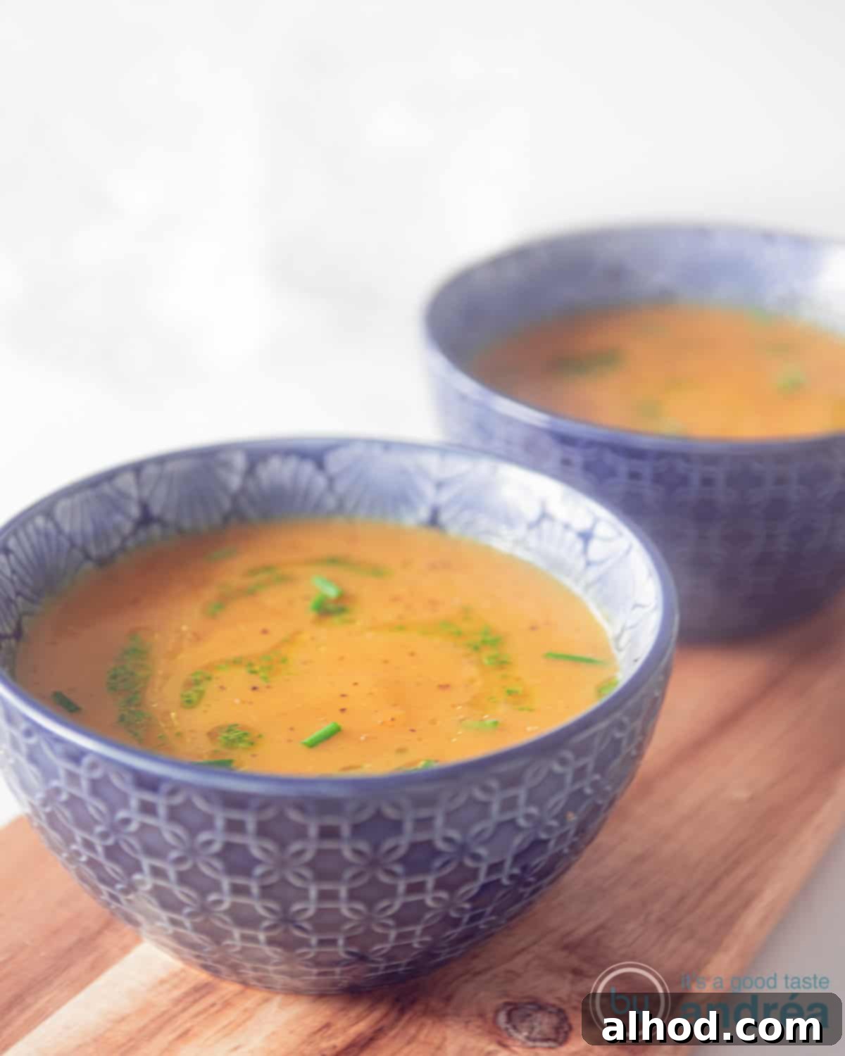 Naturally Creamy Pumpkin Soup 3 two blue bowls with dairy-free pumpkinsoup on a wooden board.
