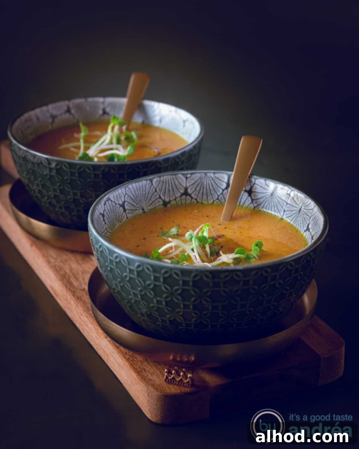 Creamy Coconut Pumpkin Soup 3 Two bowls filled with pumpkin soup with coconut milk on a wooden board on a dark background