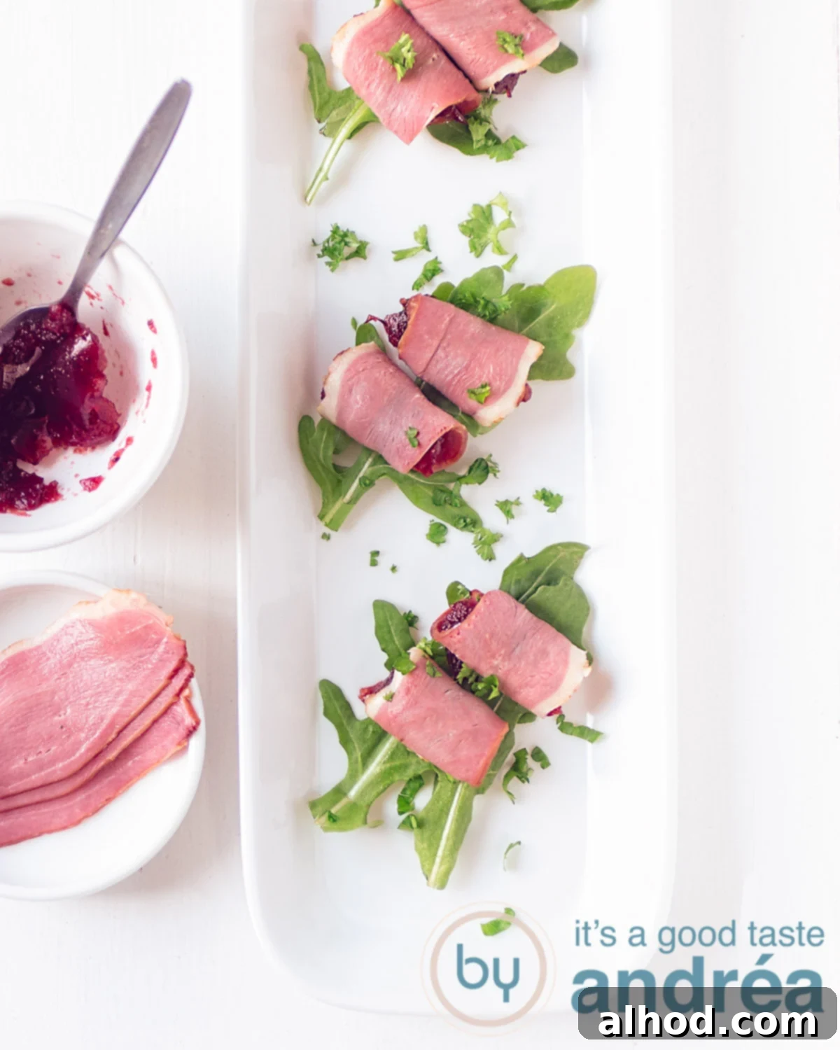 Three amuse-bouche with duck breast filet, cranberry compote on a bed of arugula, elegantly arranged on a plate