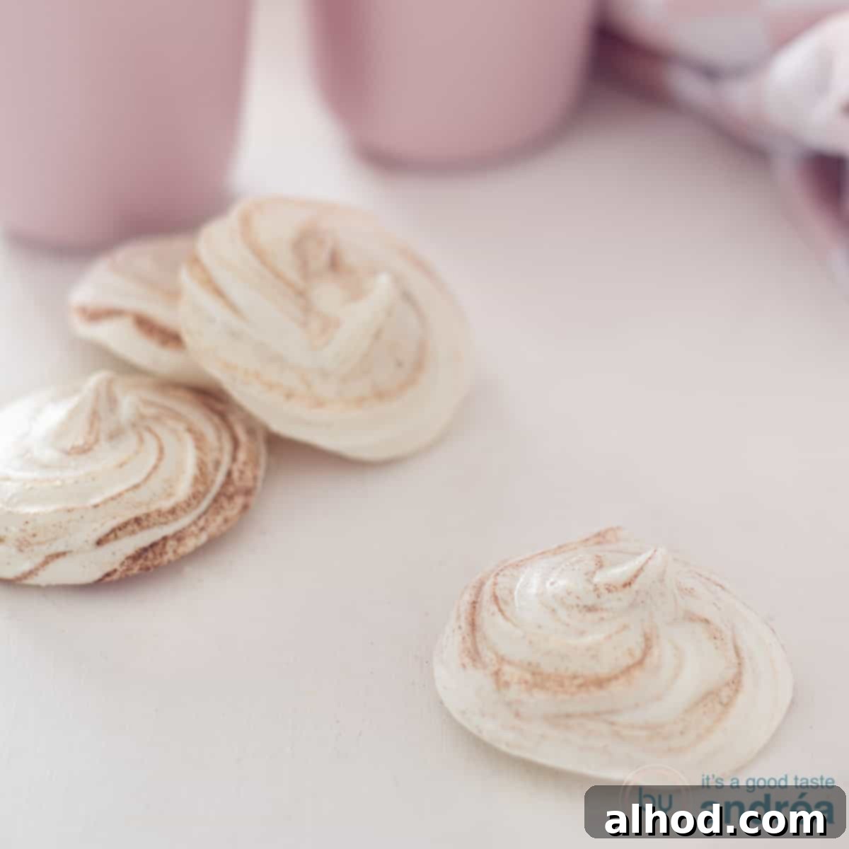 Snowy Kisses 4 A white background with winter meringues. In the back two pink cups.