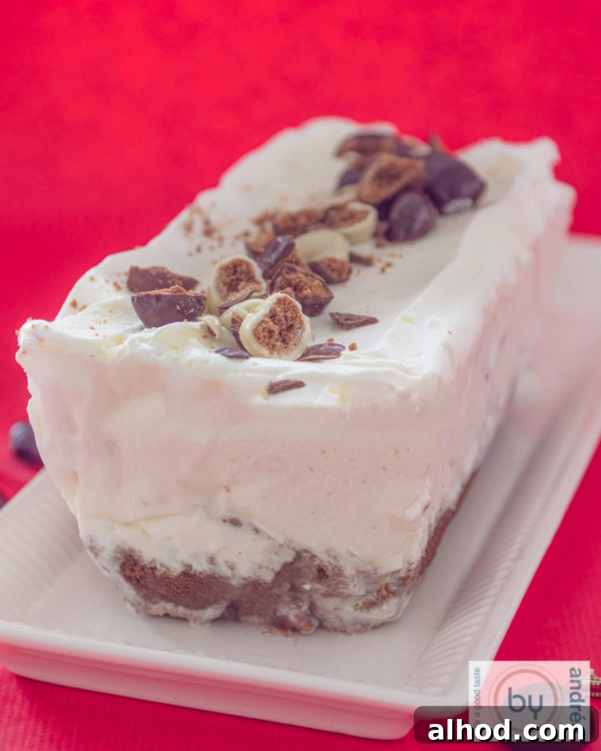 Dutch Pepernoten Holiday Ice Cream Dream 3 A white cake stand with a chocolate gingerbread ice cream cake on a red background.