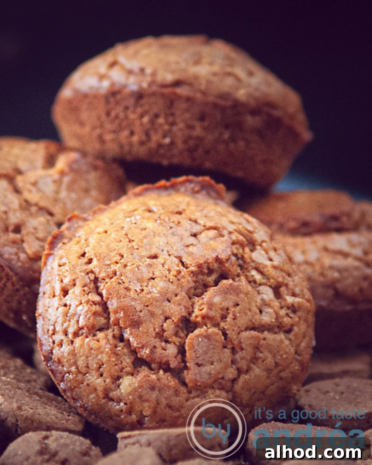 Dutch Pepernoten Surprise Muffins 2 A macro shot of gingerbread muffins placed on a layer of gingerbread cookies. A black background.