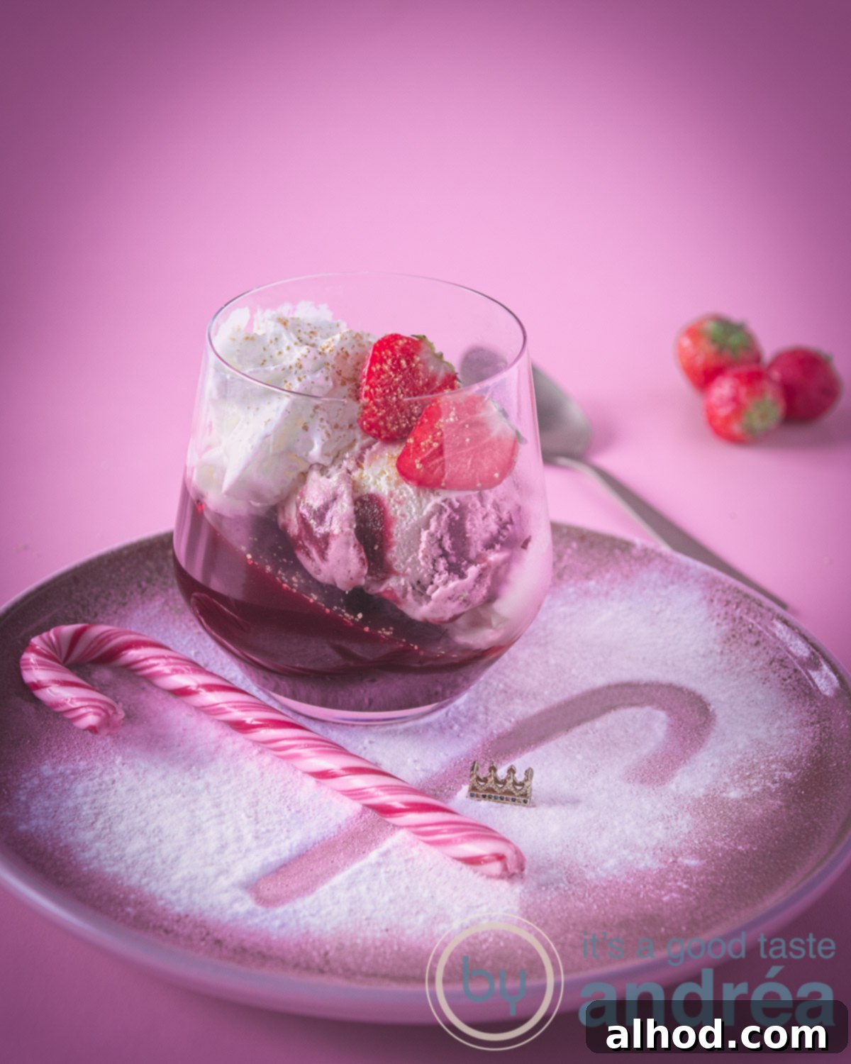 Aardbeientoetje voor de kids - Two elegant glasses filled with layers of angled strawberry jelly, creamy strawberry ice cream, and fluffy whipped cream, topped with fresh red strawberries. The dessert is vibrant and festive, perfect for kids and adults during Christmas.