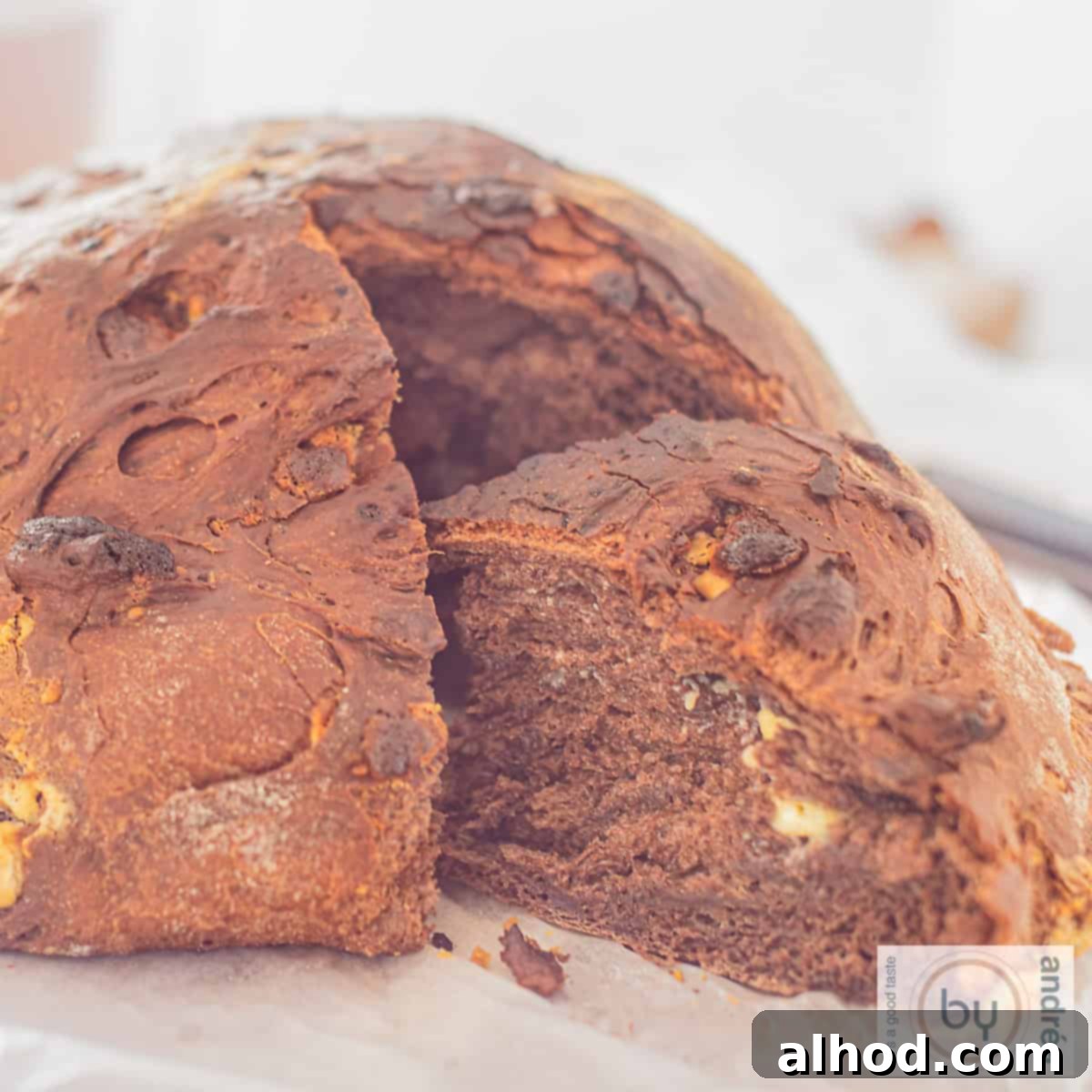 Artisan Double Chocolate Chunk Loaf 4 A square picture with chocolate bread, a slice cut out.