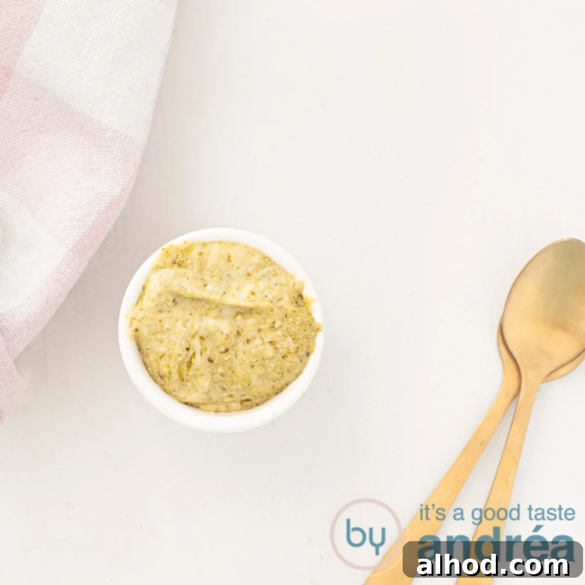 A square photo with a spoonful of pesto mayonnaise, two golden spoons on the side