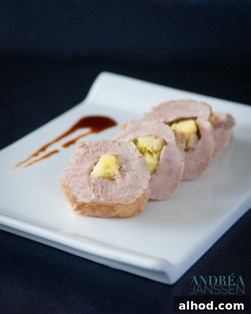 Unforgettable Yuletide Feast 9 Slices of pork tenderloin stuffed with apple, pistachios, and thyme, elegantly arranged on a serving dish.