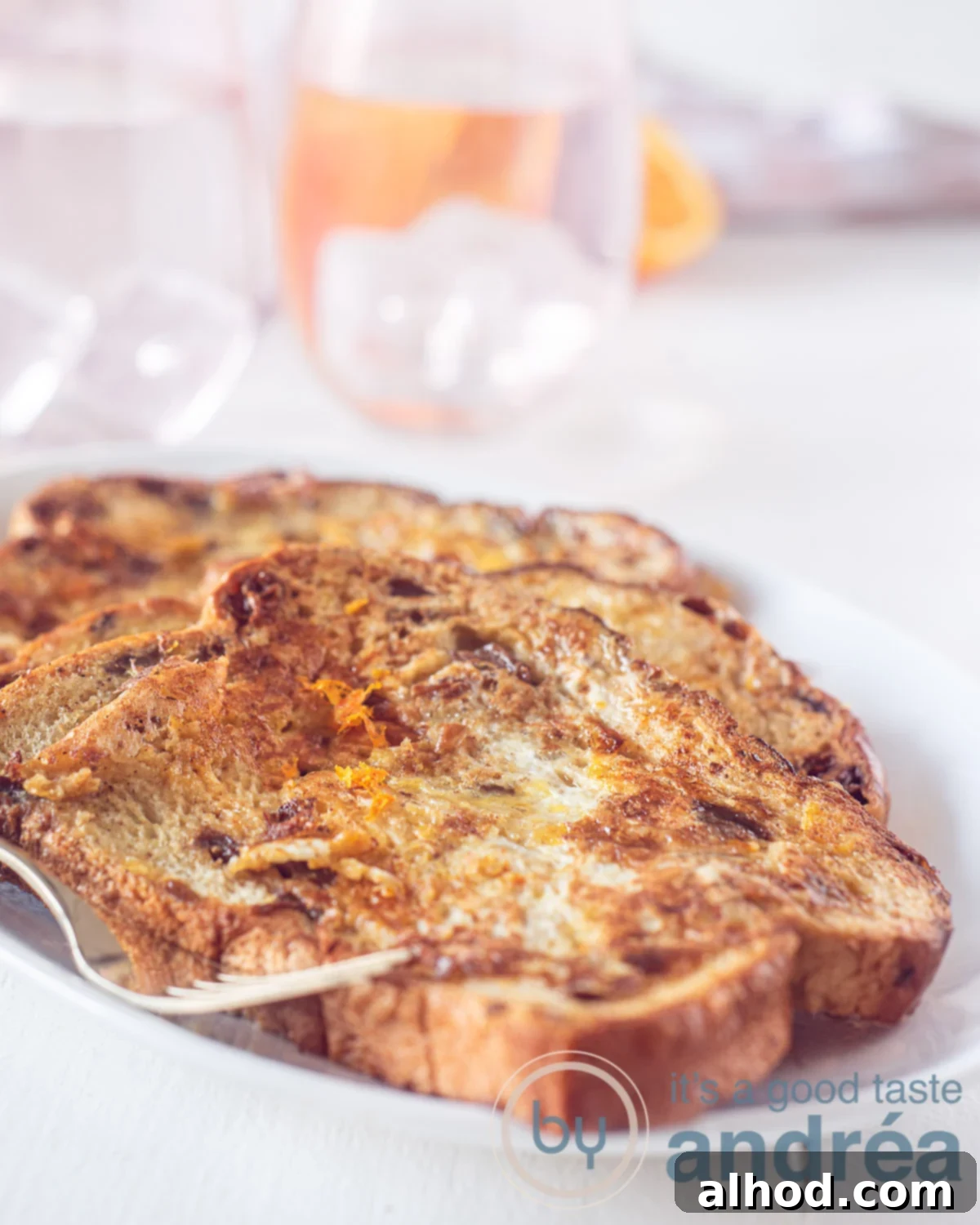 Decadent French Toast 3 French toast deluxe on a plate, garnished with orange zest and honey.