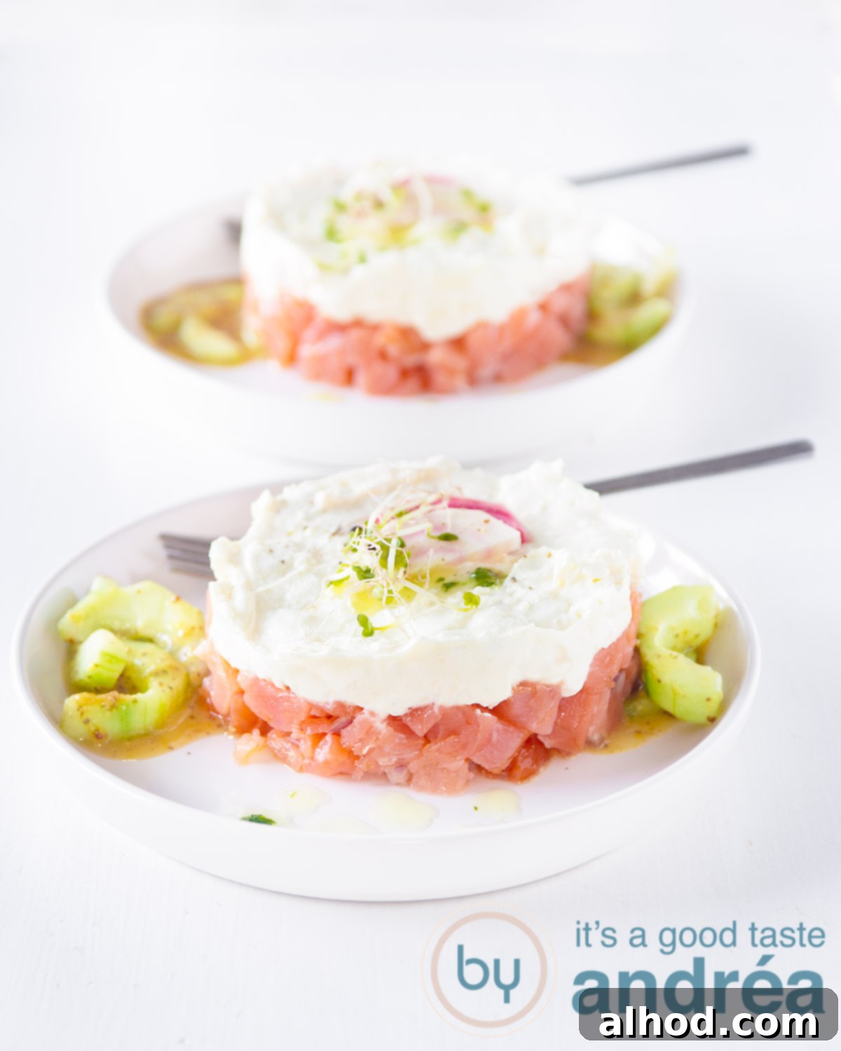 Gourmet Salmon and Chèvre Stacks 5 Two exquisitely plated towers of smoked salmon and goat cheese, garnished with cress and sliced beets, ready to be served as an impressive appetizer.