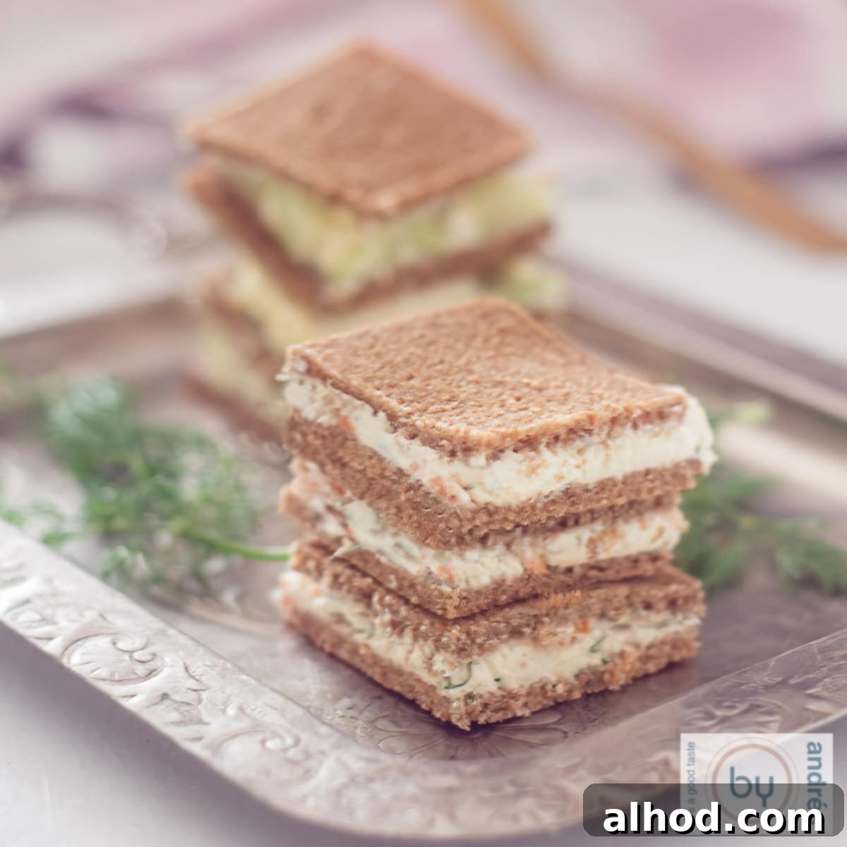 Elevated Rye Sandwiches 3 A square picture with a silver plate with a staple of rye bread sandwiches filled with cream cheese salmon or cucumber.