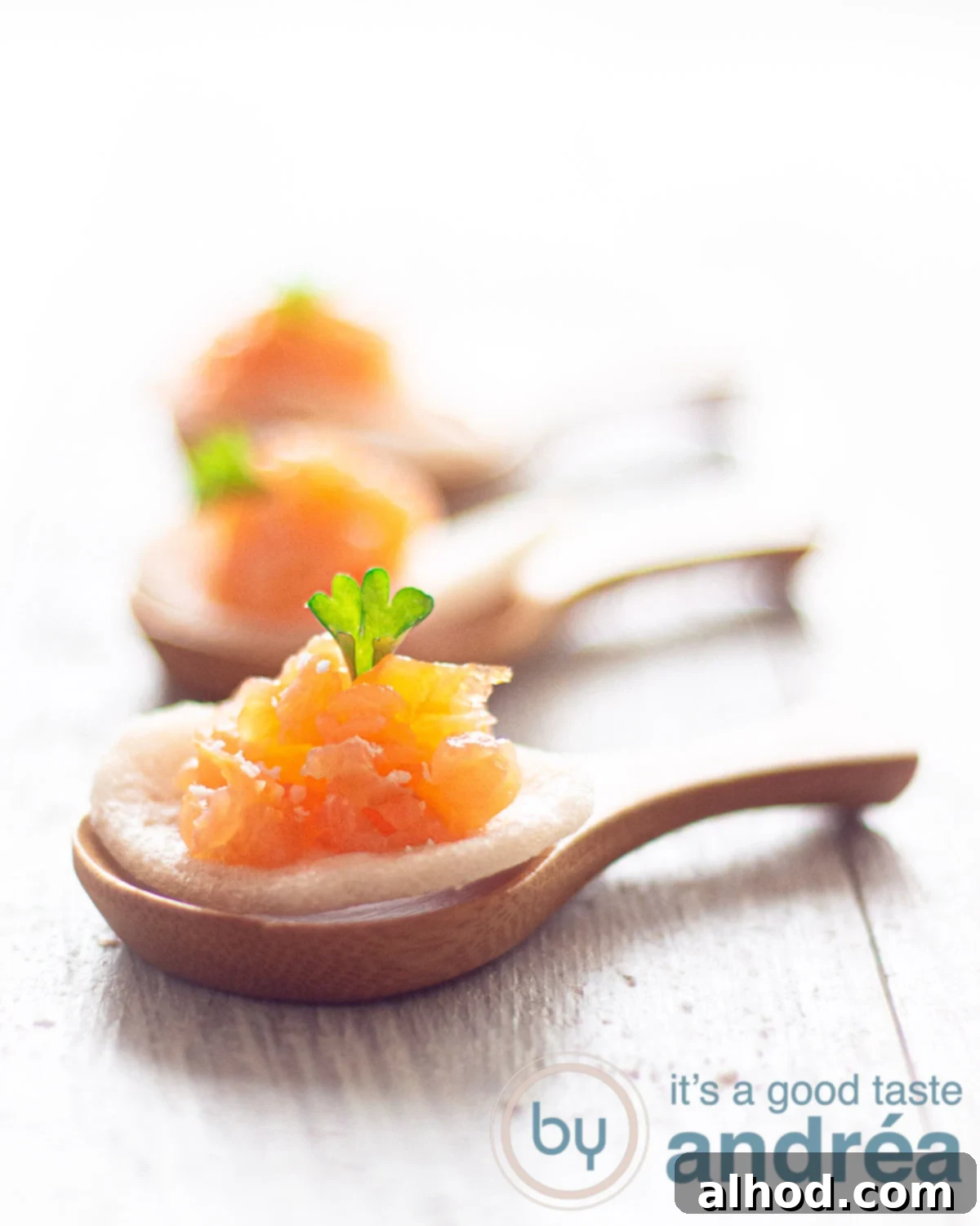Salmon and Crispy Prawn Crackers 5 Close-up of three elegant bamboo spoons, each holding a crisp prawn cracker topped with beautifully marinated smoked salmon and a sprinkle of fresh herbs, presented on a clean white surface for a sophisticated appetizer display.