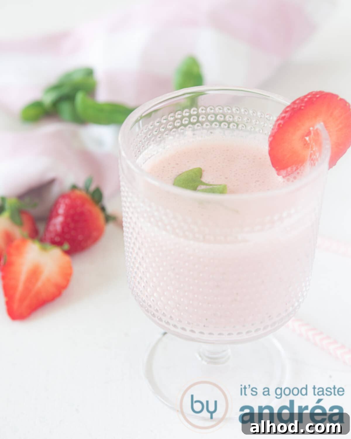 Sweet and Savory Strawberry Basil Smoothie 2 A glass with strawberry yogurt smoothie. Some strawberries and basil in the background