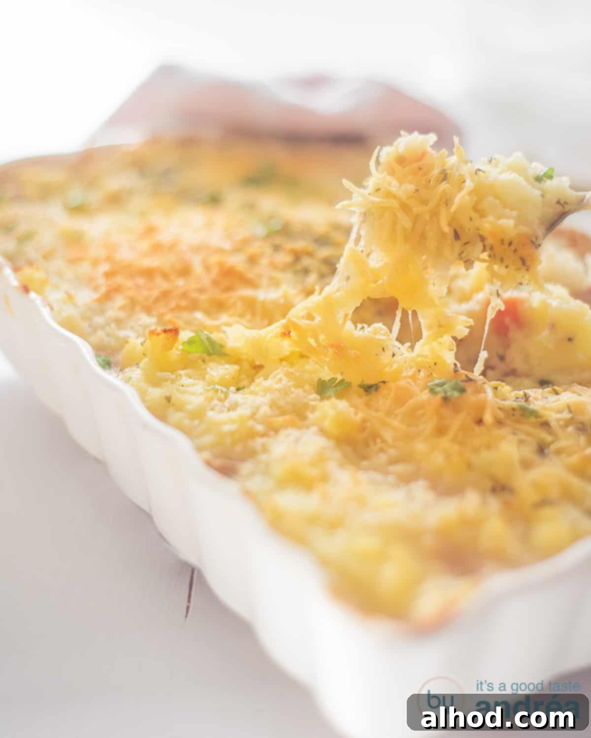 Sea Shepherd's Pie 3 Shepherd's Pie with Tuna in a white casserole dish. A spoon is taken out some cheesy mashed potato.