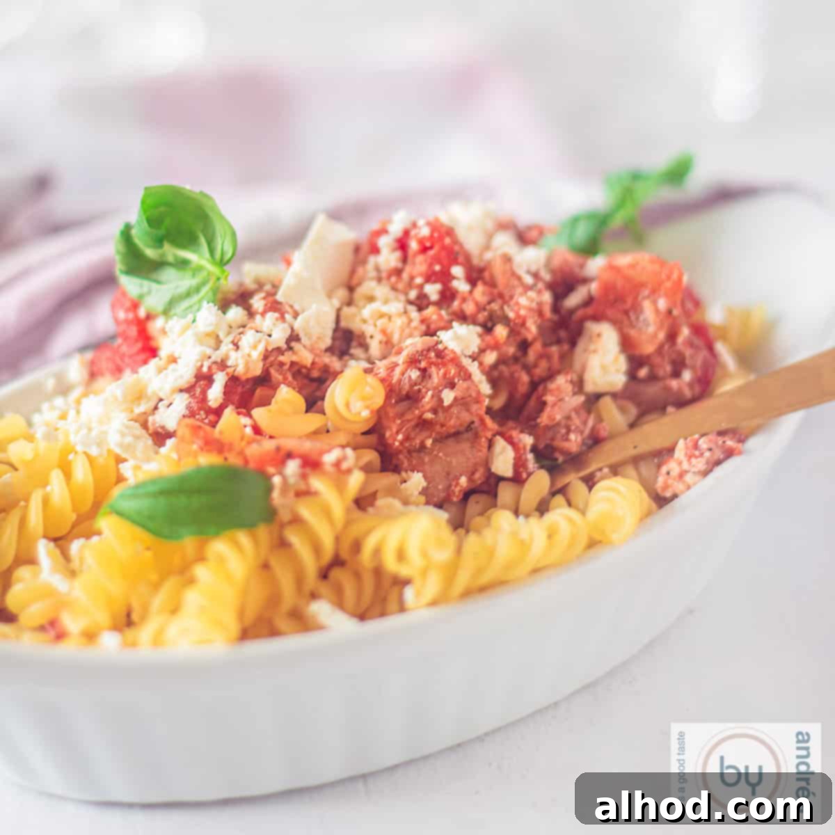 20-Minute Mediterranean Tuna Feta Pasta 4 A square photo with a white oven dish with pasta with feta, tuna and tomato