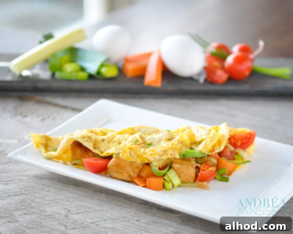 Savory Chicken and Vegetable Stuffed Omelet 2 A delicious and healthy filled omelet with chicken and vegetables on a white plate, perfect for a quick dinner