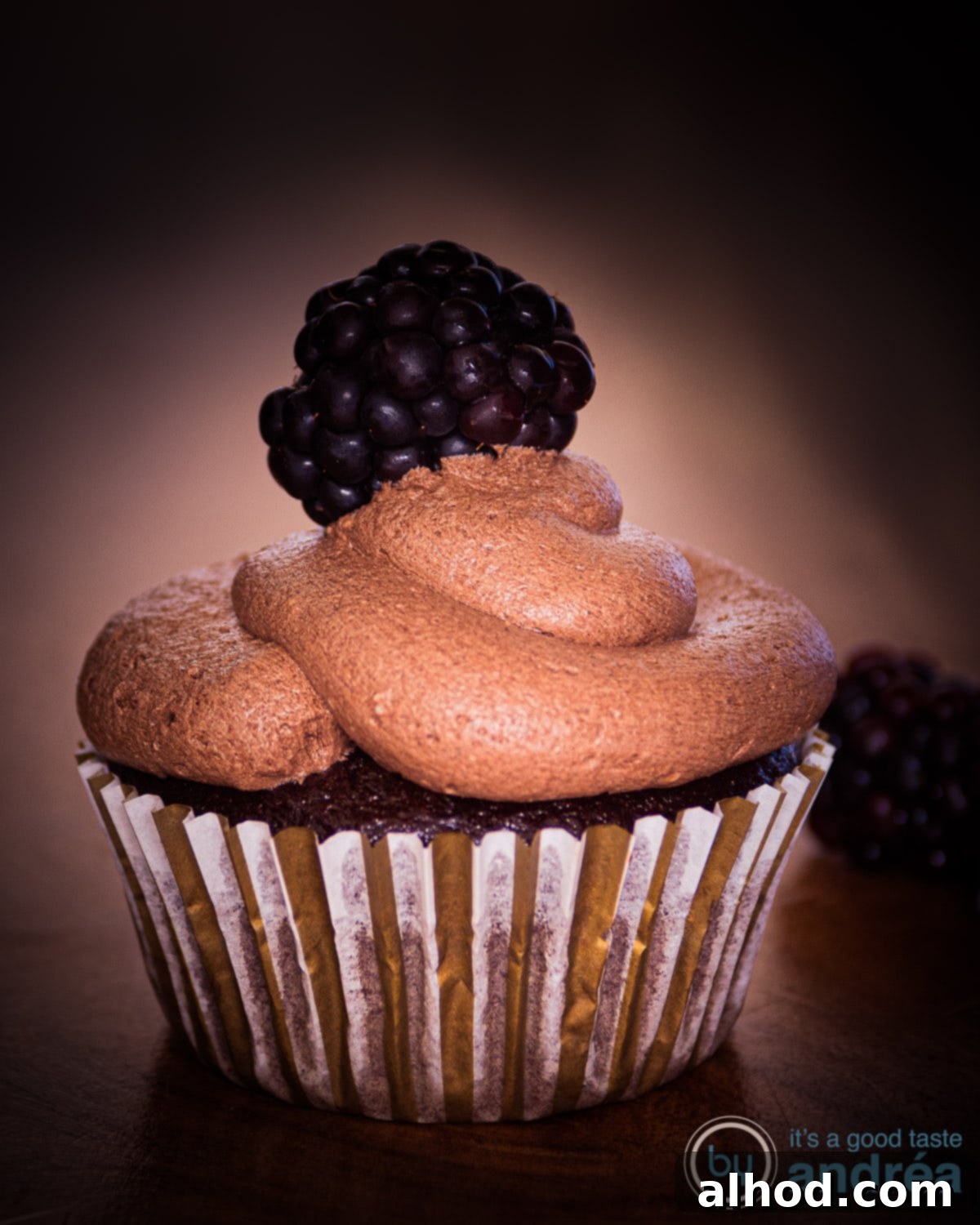 Easy Dairy-Free Chocolate Cupcakes 2 A delectable dairy-free chocolate cupcake topped with rich, creamy frosting, presented elegantly on a dark brown surface, highlighting its inviting texture and deep chocolate color.