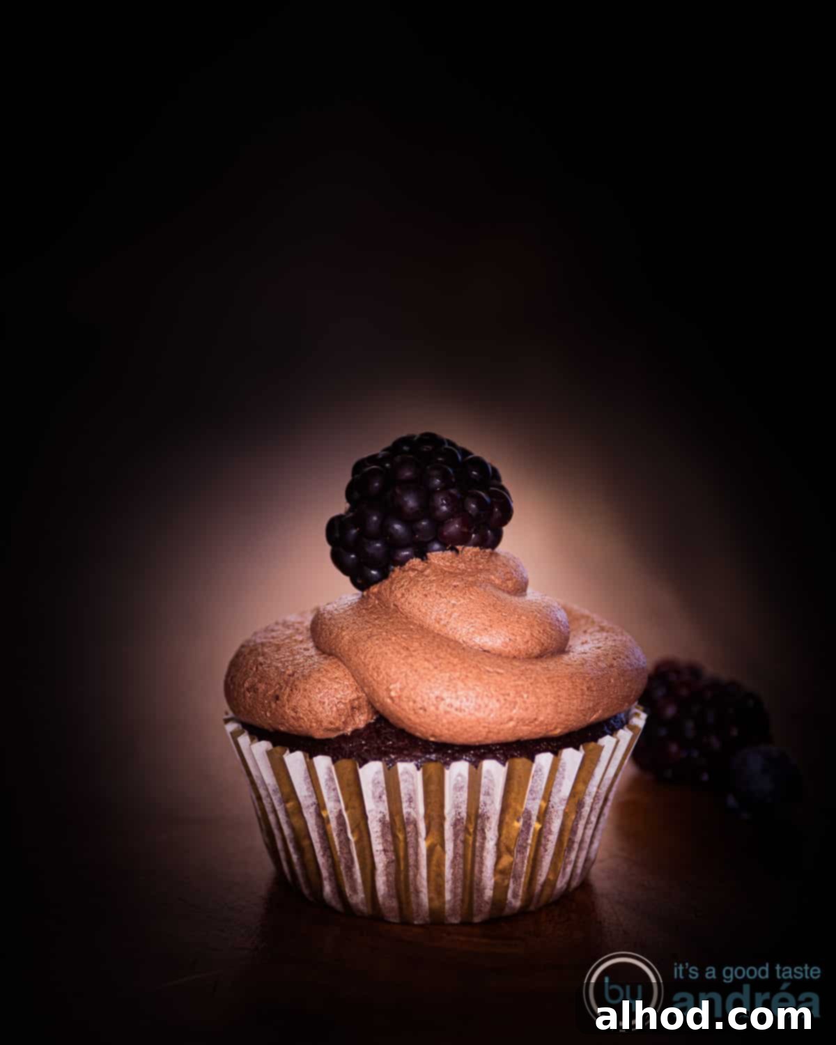 Easy Dairy-Free Chocolate Cupcakes 9 A beautifully decorated vegan chocolate cupcake, featuring a generous swirl of rich chocolate frosting, set against a rustic brown background, ready for enjoyment.