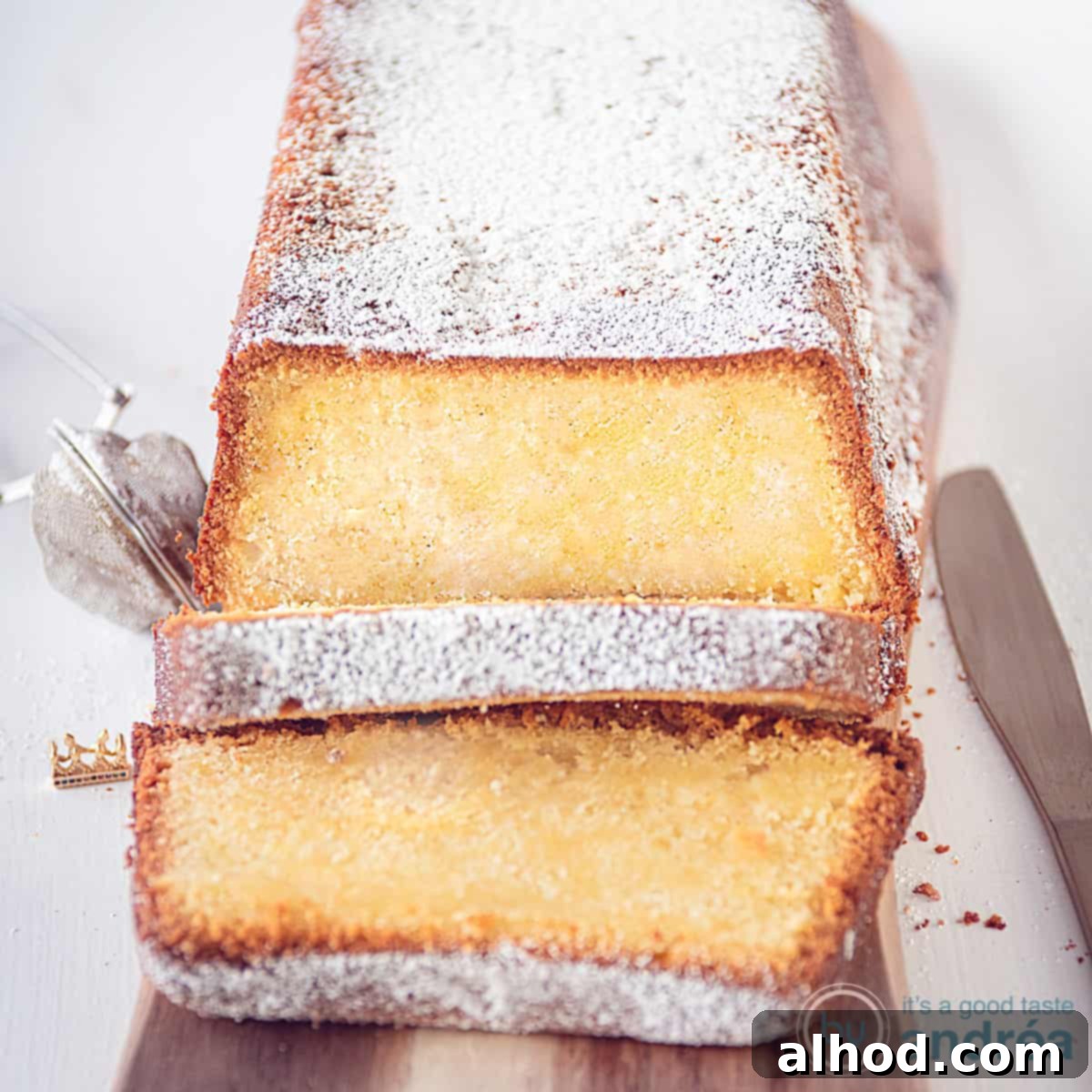 Effortless Cream Cheese Pound Cake Perfection 4 A square photo with a wooden board holding a cake made with cream cheese and sour cream. Two slices cut off.