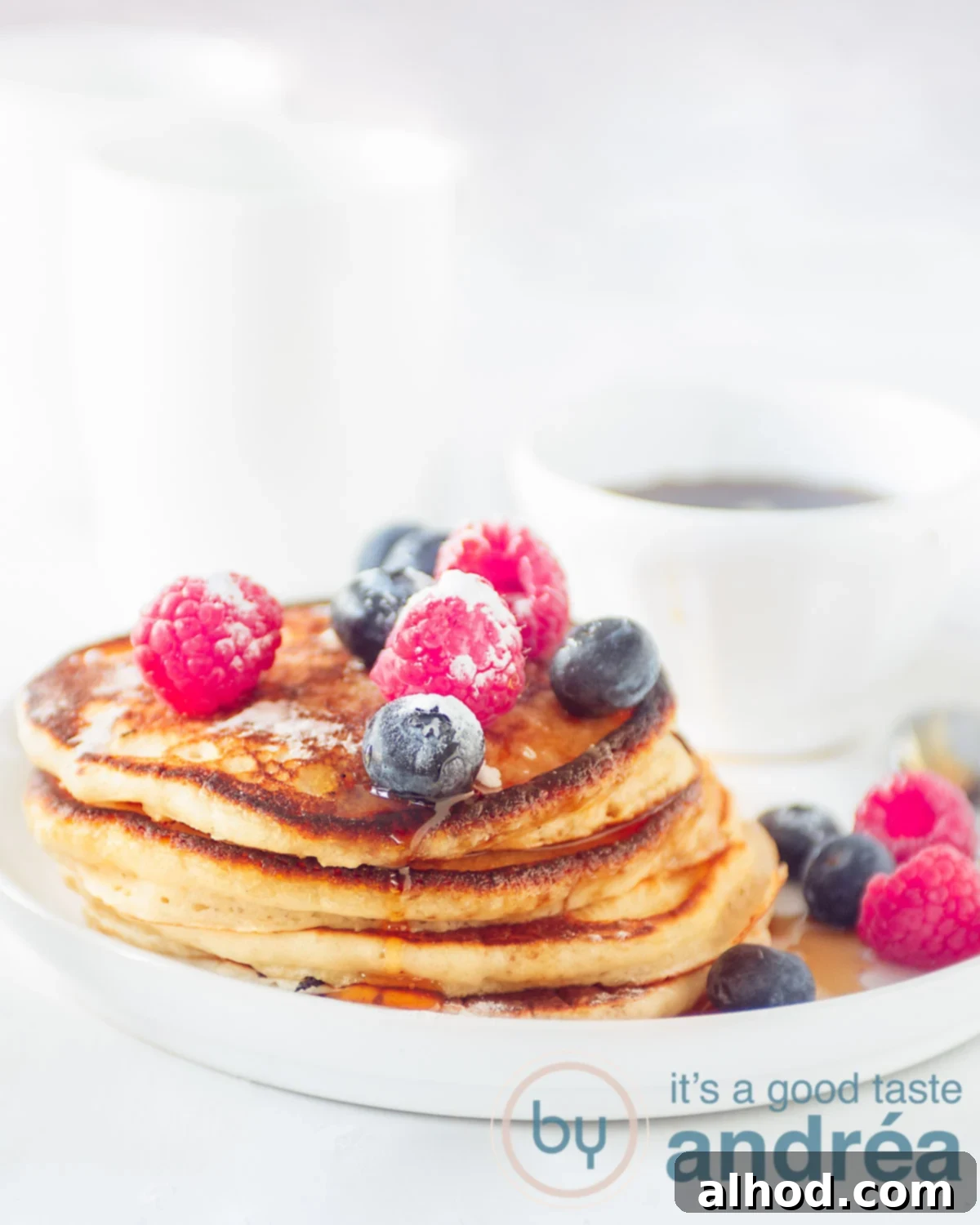 Cloud-Like American Pancakes 6 A stack of pancakes on a white plate with fresh fruit