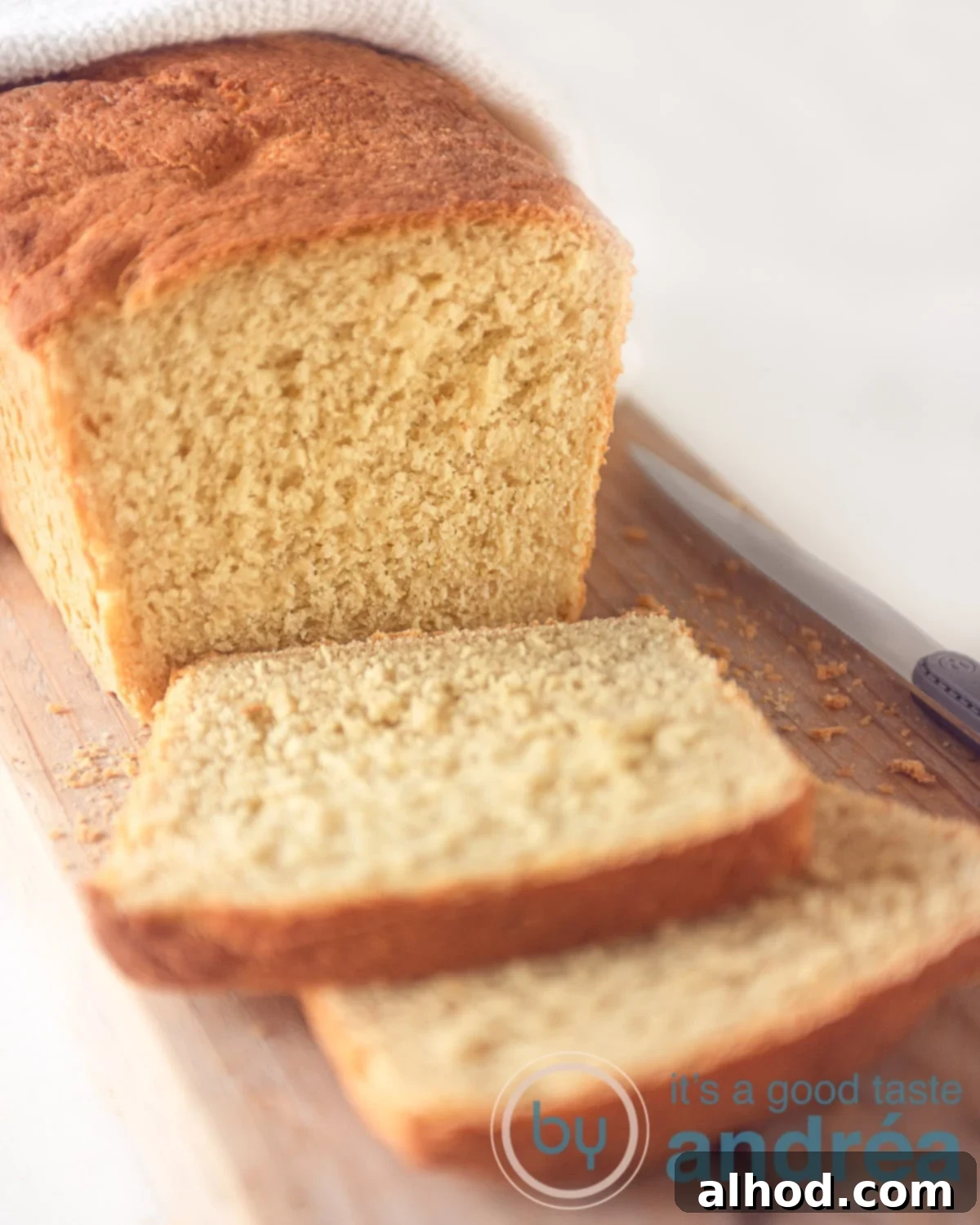 Easy Scratch-Made Vegan Cornbread Loaf 2 A loaf cornbread on a wooden bord. Two slices cut off.