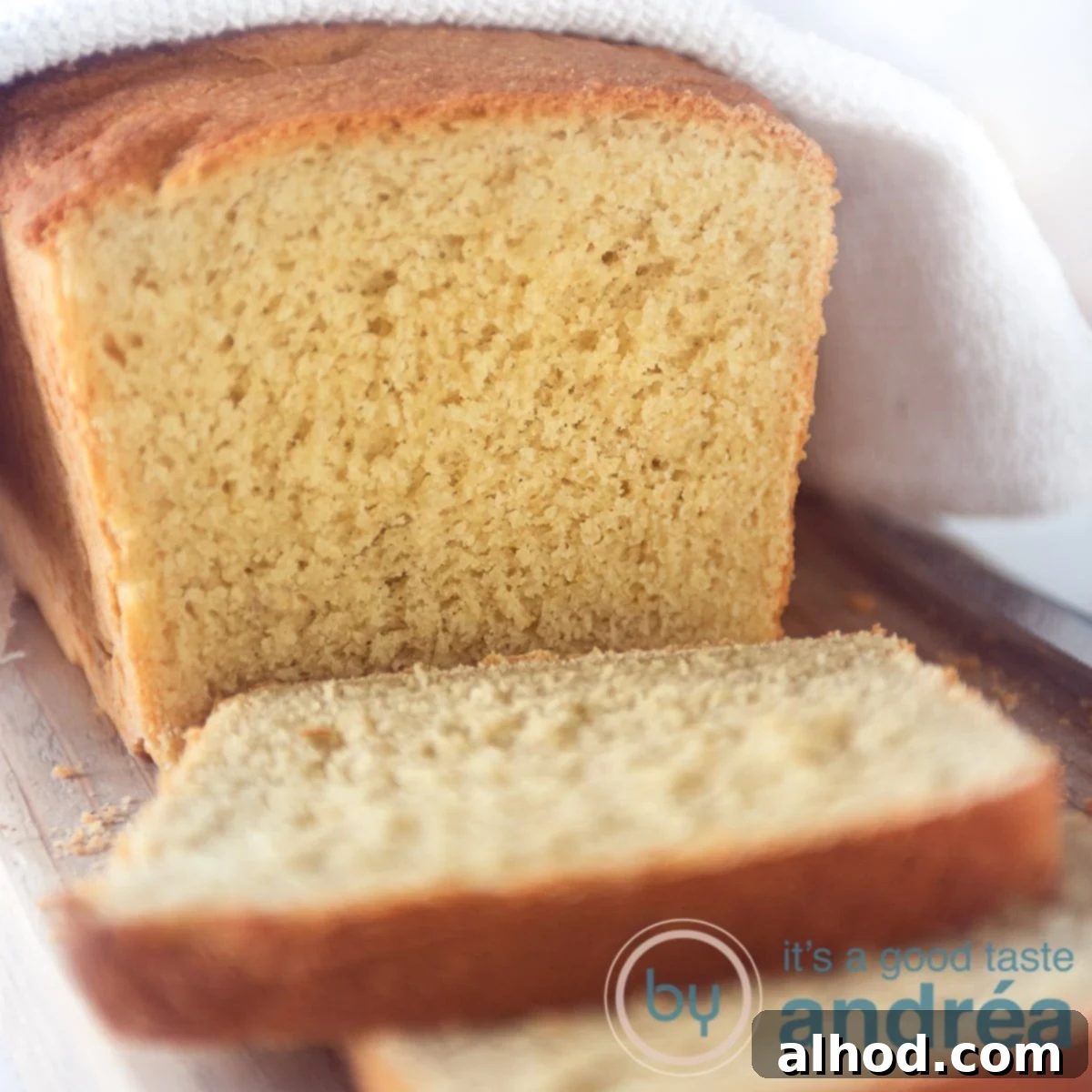 Easy Scratch-Made Vegan Cornbread Loaf 9 a square photo with cornbread. A white towel on top. Some slices cut off