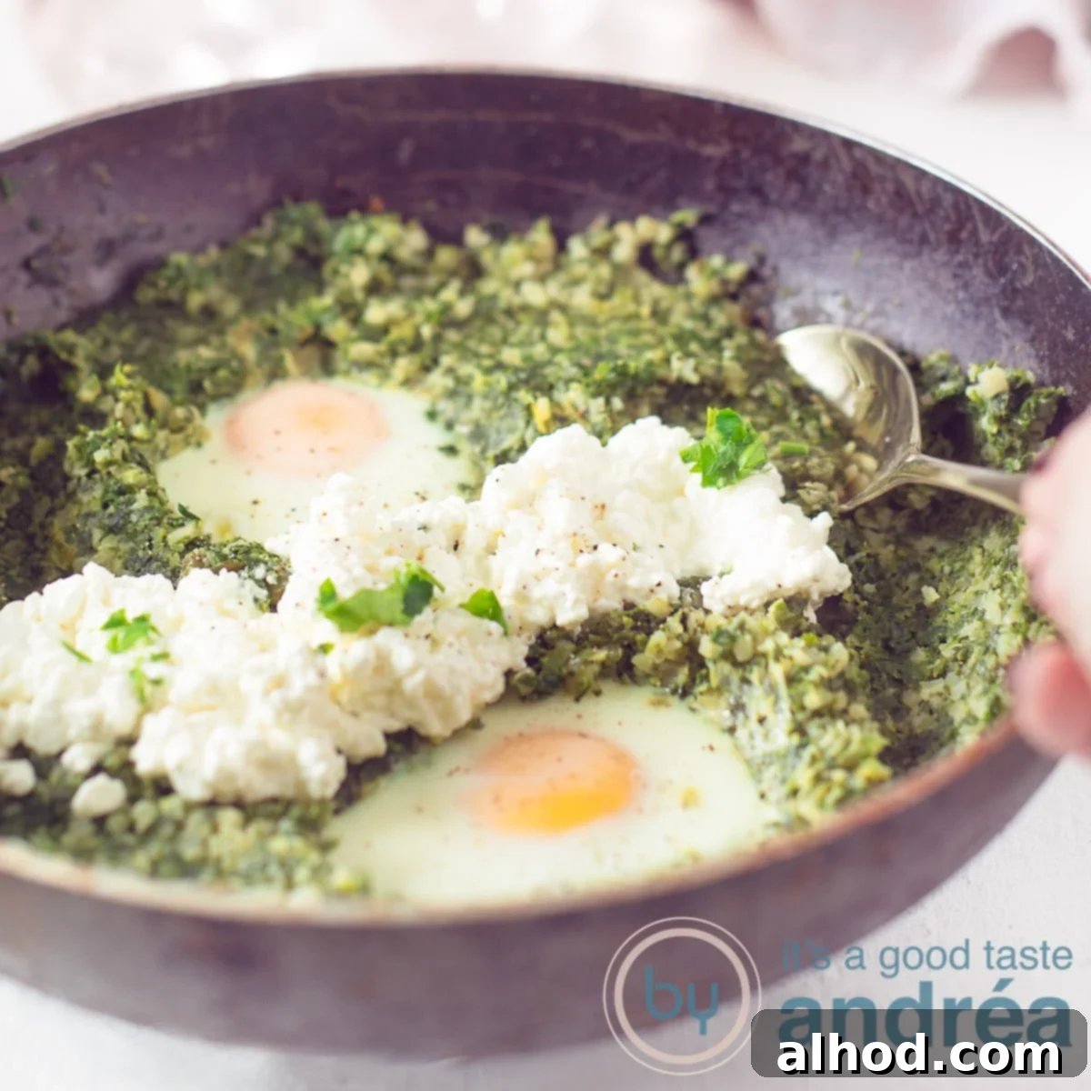 Silky Cauliflower Risotto with Fresh Spinach and Leeks 6 A square photo with a black pan filled with a cauliflower rice, leek and spinach dish with egg and cottage cheese.