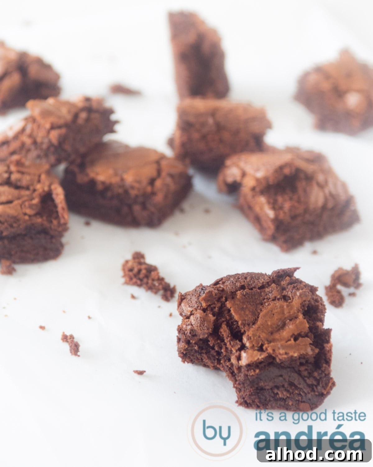 Master Fudgy Brownies in 4 Simple Steps 9 Homemade chocolate brownies on a white suface. The front one has taken a bite out.