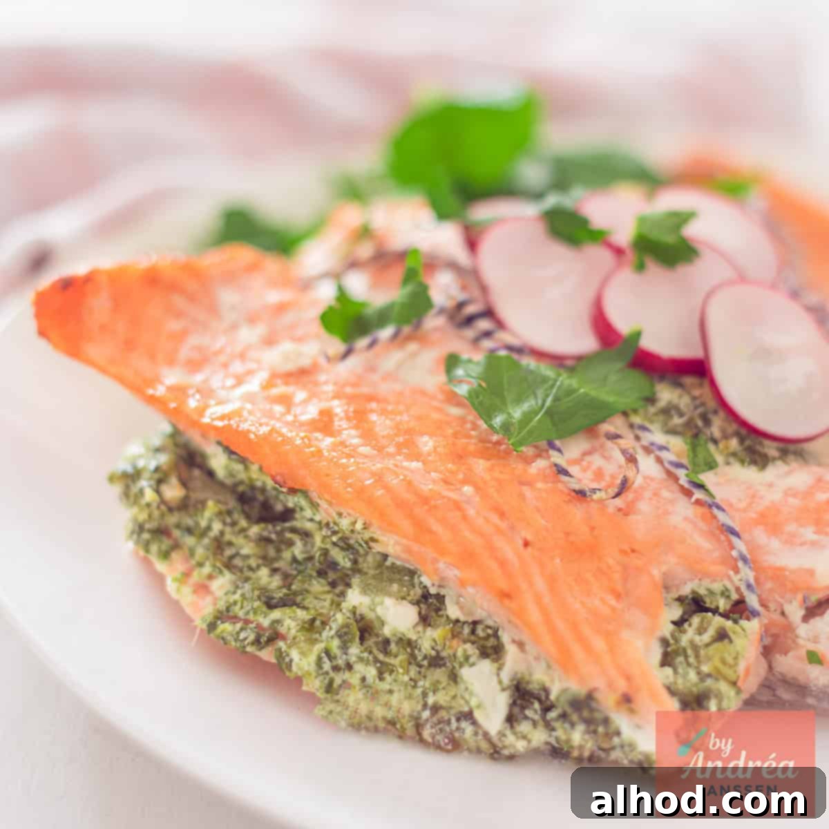 Creamy Spinach & Celery Stuffed Salmon 4 A square photo of a portion of a salmon fillet filled with a creamy spinach filling