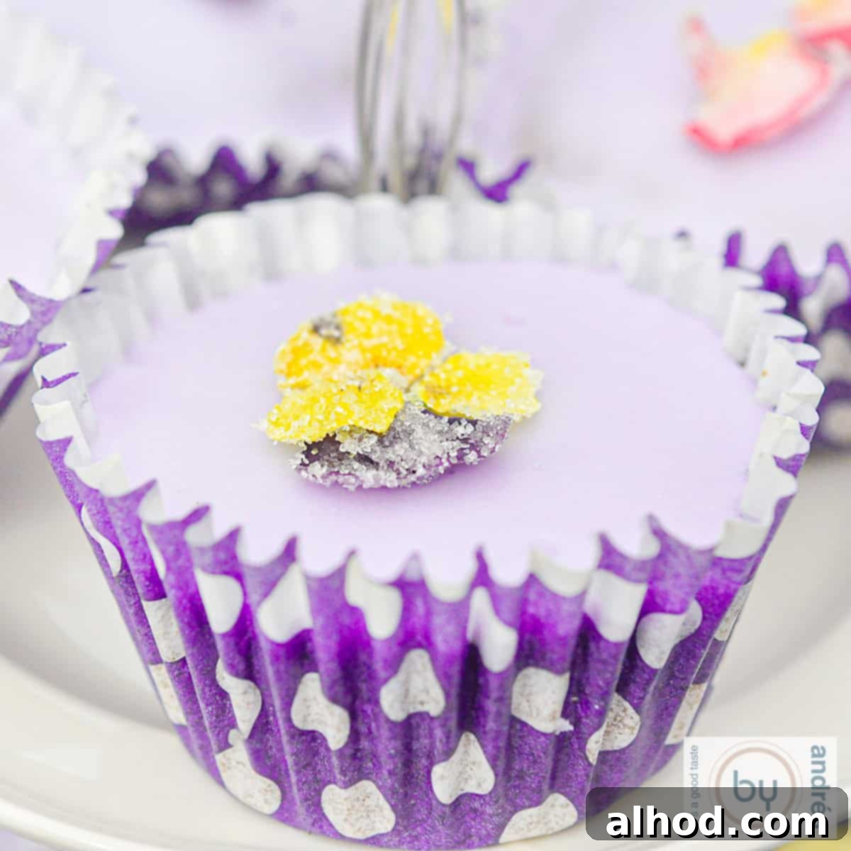 Enchanting Lavender Chocolate Cupcakes 3 A square photo featuring a lavender cupcake with a yellow violet sugar flower.