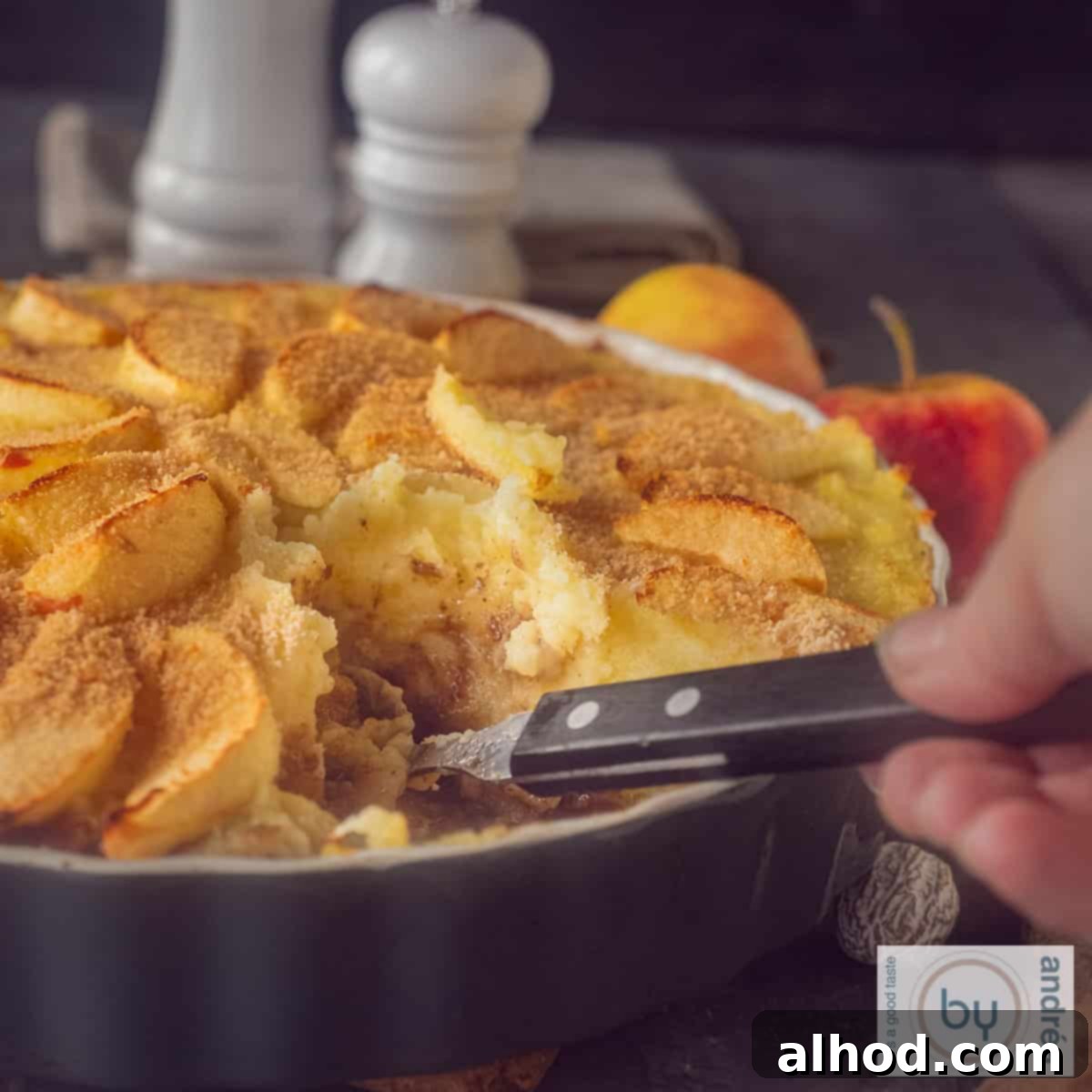 Meltingly Tender Dutch Rump Pot Roast 4 A square photo of part of a casserole with stew, mashed potatoes, apples. A scoop of food is taken out.
