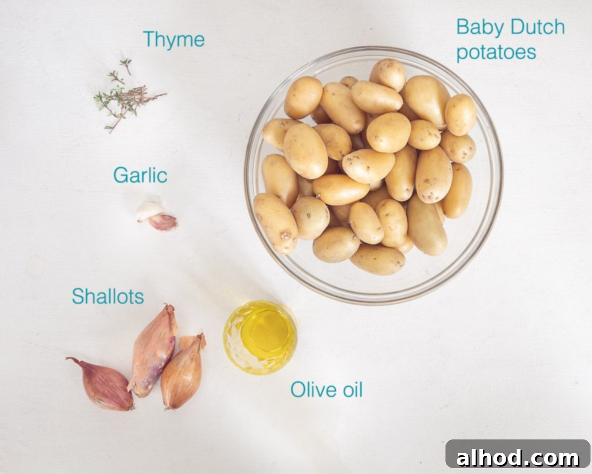 Golden Crispy Oven Roasted Baby Dutch Potatoes 3 Individual ingredients for Oven Roasted Baby Dutch Potatoes laid out on a white background, including small potatoes, garlic, thyme, shallots, and olive oil.