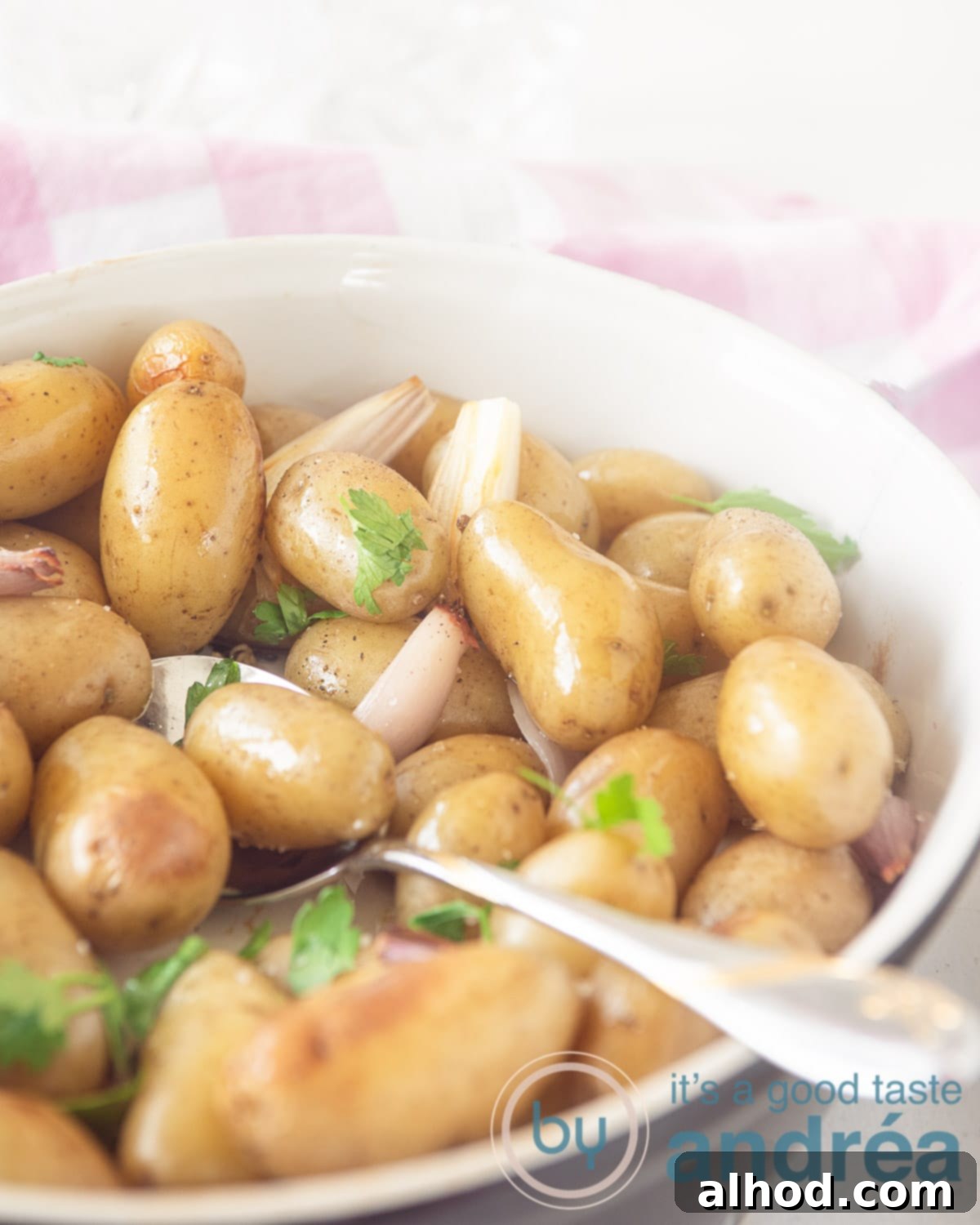 Golden Crispy Oven Roasted Baby Dutch Potatoes 5 Close-up photo of roast potatoes with thyme, shallots, and garlic, showing their crispy texture and golden color.