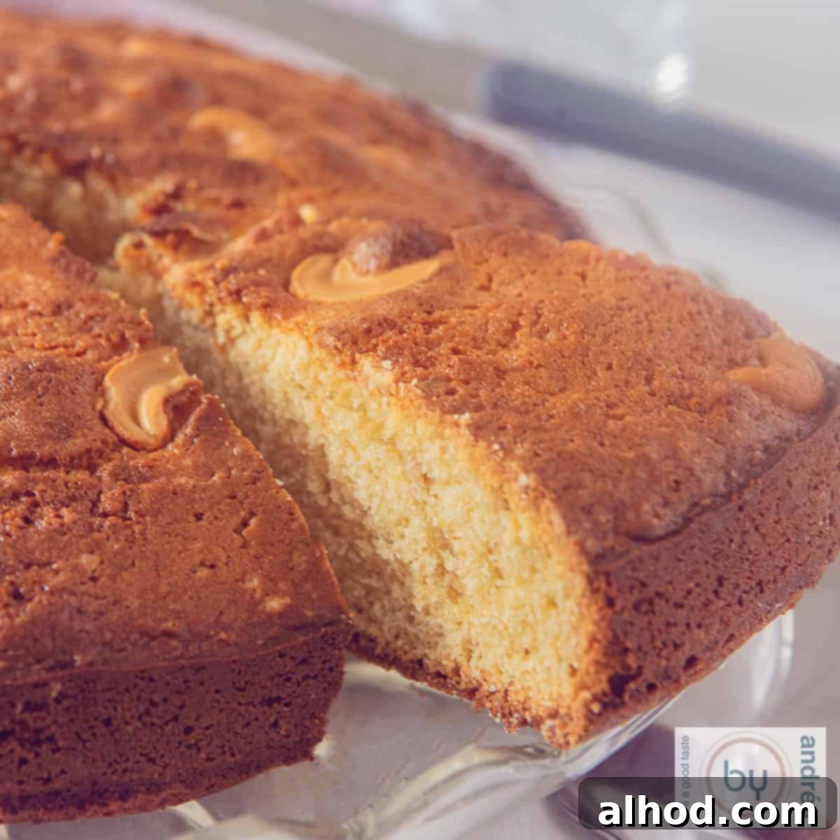 Fragrant Homemade Mawa Cake with Cardamom 4 A square photo of a slice of an Indian cake with mawa, cardamom and cashew nuts. A corner cut out.