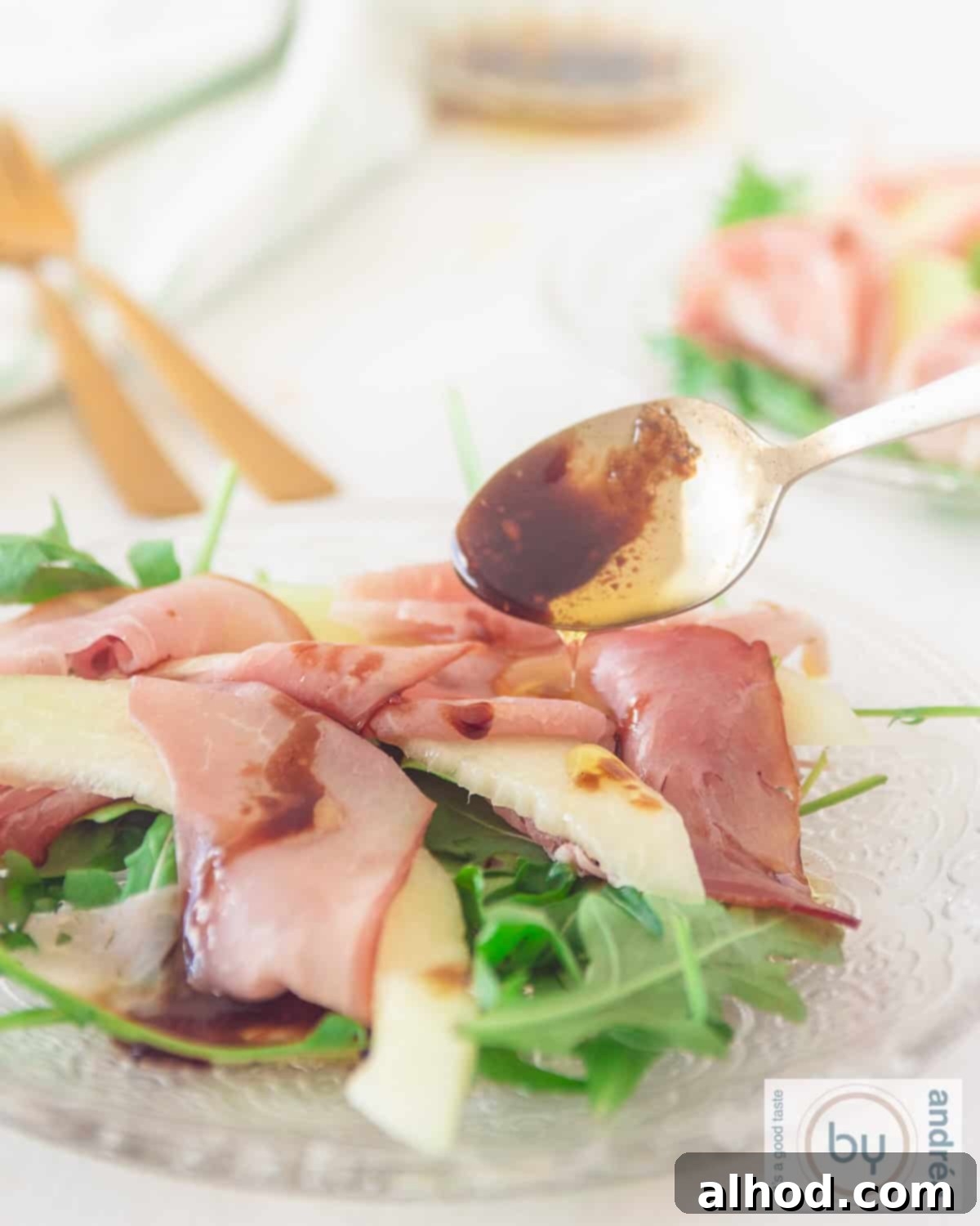Summer Melon and Parma Ham Delight 2 Refreshing Summer Salad with Galia Melon, Parma Ham (Prosciutto), Arugula, and Balsamic Glaze in a glass bowl, perfect for a single serving.