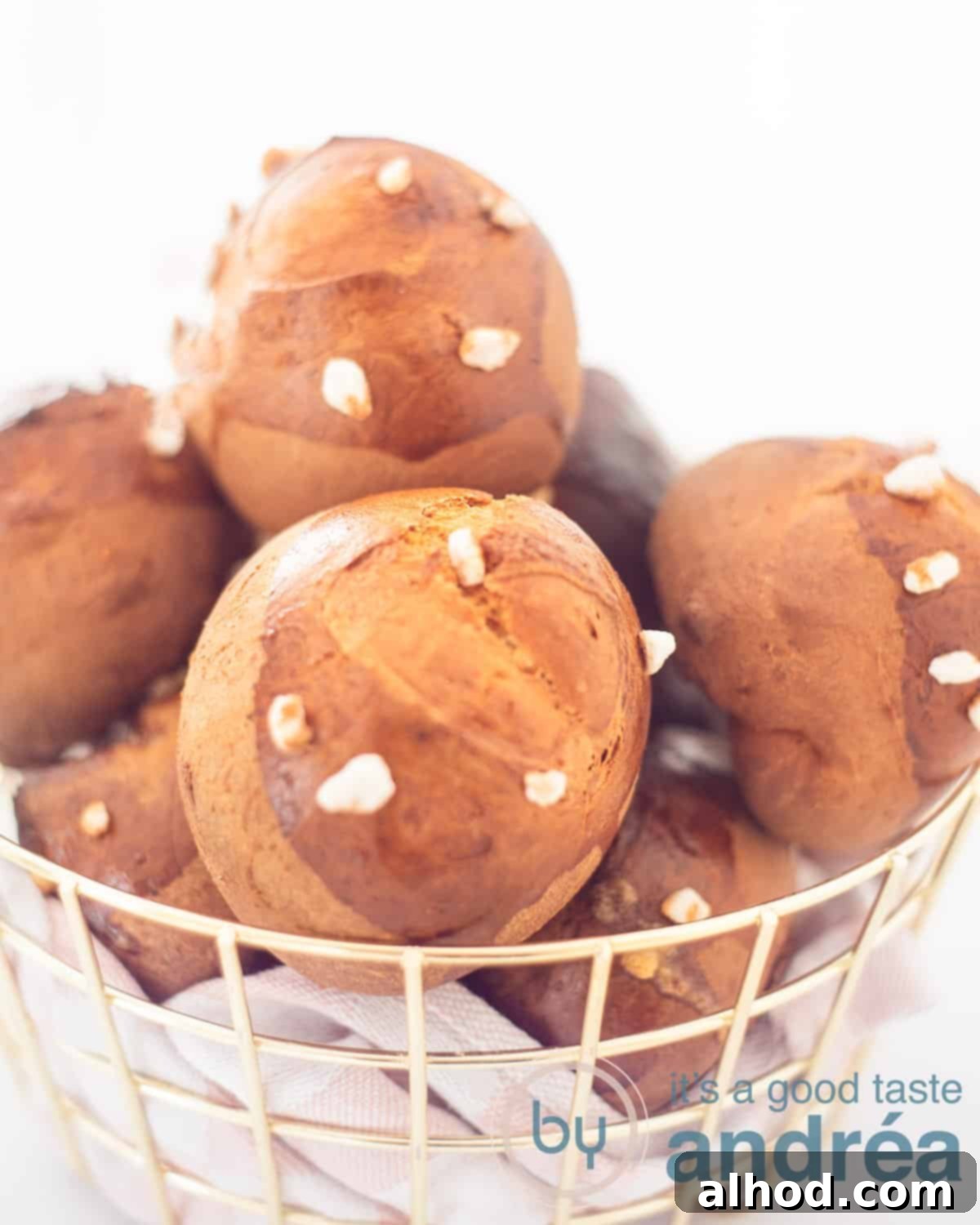 Dutch Pearl Sugar Buns 2 A basket filled with sugar rolls, lying on a pink white tea towel on a white background