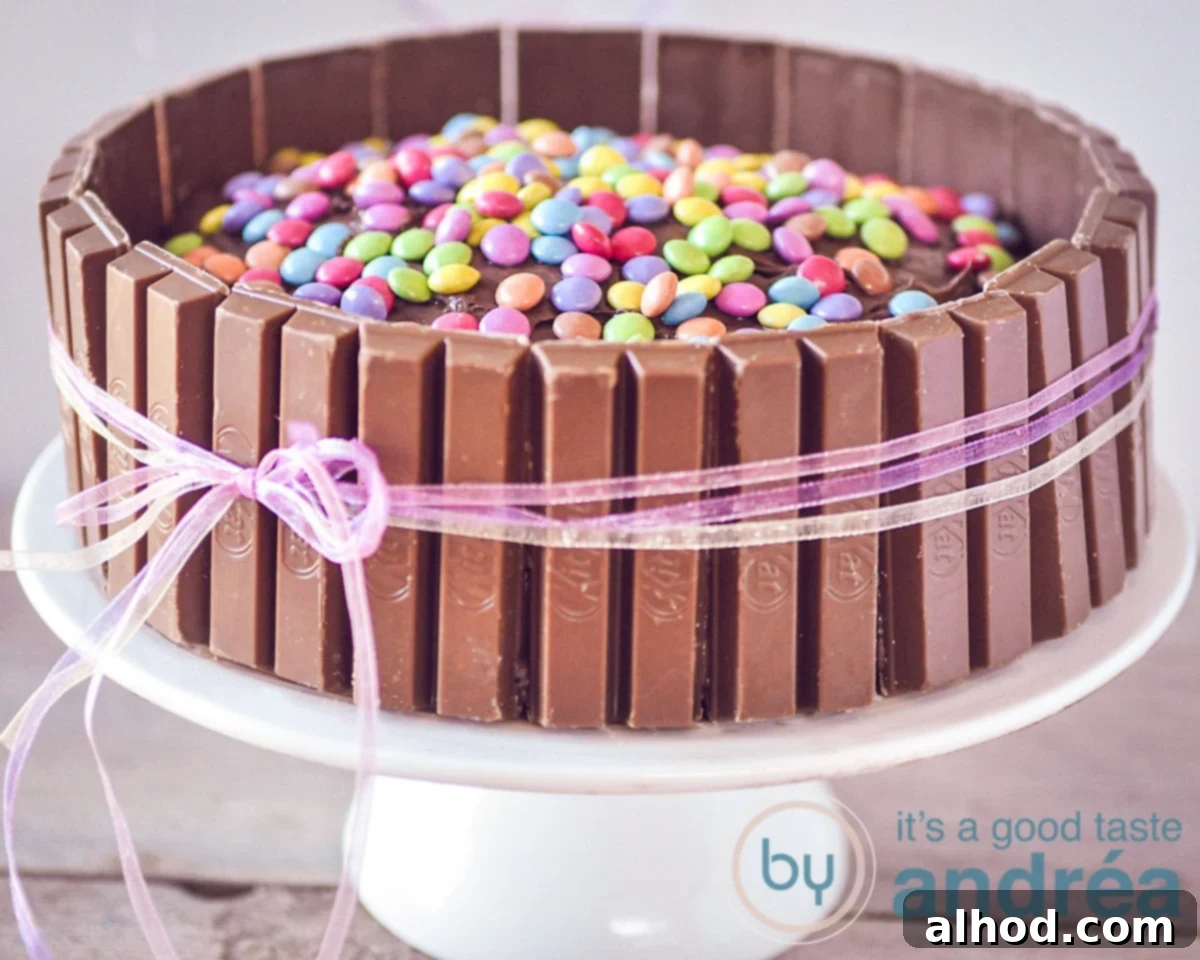KitKat Smarties Delight 3 A vibrant KitKat Smarties cake, perfectly decorated with chocolate bars around the edge and a scattering of colorful Smarties on top, ready to be served at a celebration.