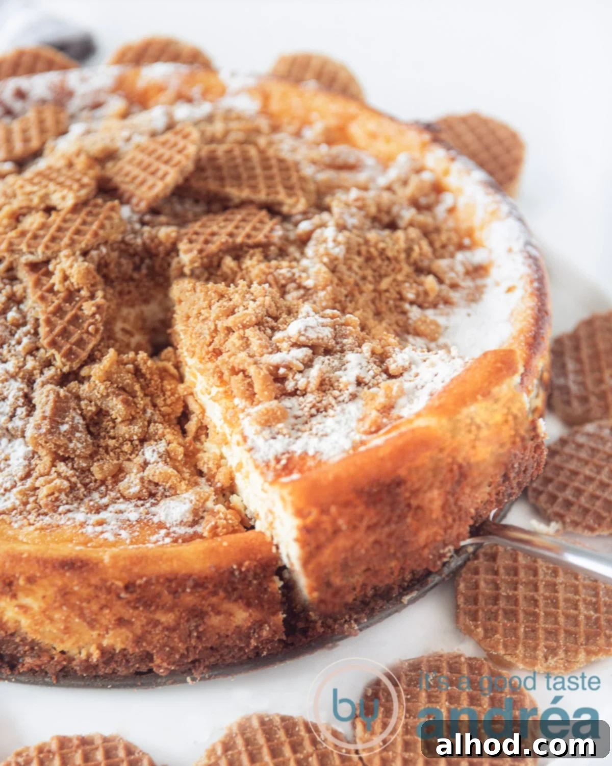 Caramel Stroopwafel Cheesecake 3 Stroopwafel cheesecake on a white plate a piece of cheesecake is taken out.