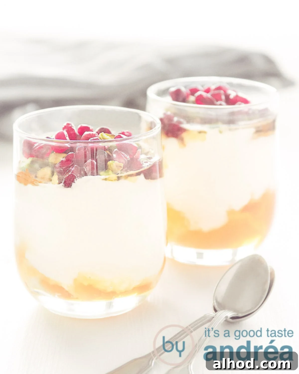 Yogurt with honey and pomegranate served in a stylish glass, featuring creamy yogurt, golden honey, and vibrant red pomegranate seeds.