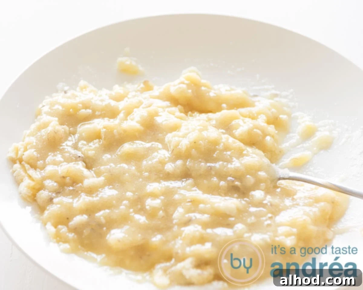 Velvety Homemade Banana Ice Cream 4 A white plate with roughly mashed bananas, showcasing their soft texture.