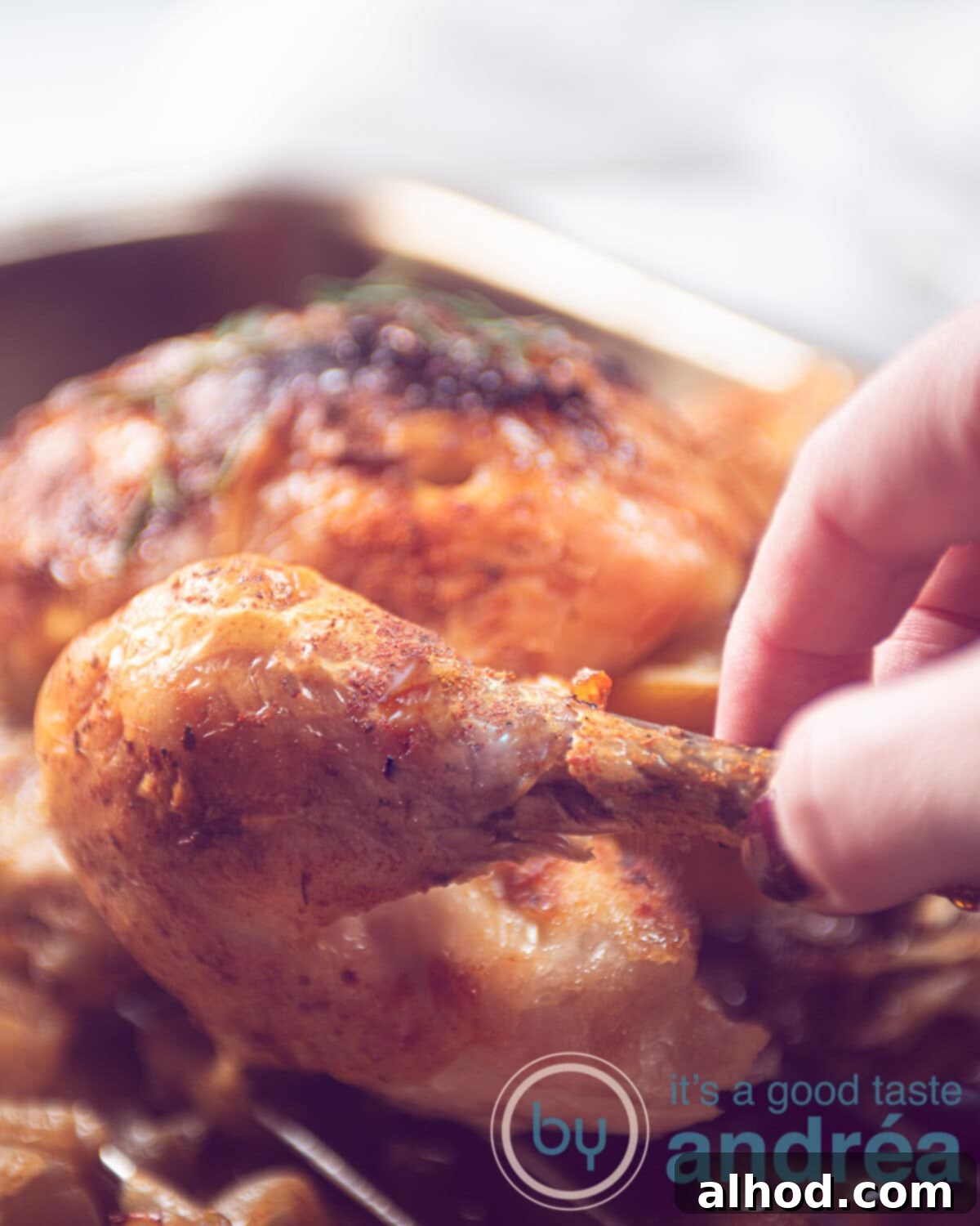 Easy Slow Cooker Rotisserie Chicken 2 a hand taking a drumstick from a whole chicken